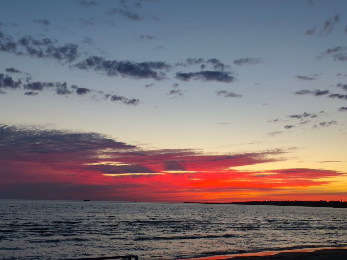 Vivid sunset colors stretch across a calm seascape.