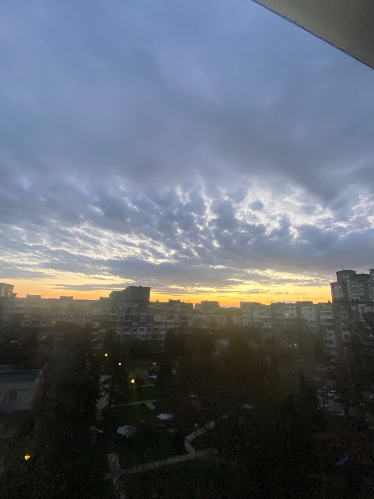 Golden twilight illuminates Sofia skyline through breaking clouds