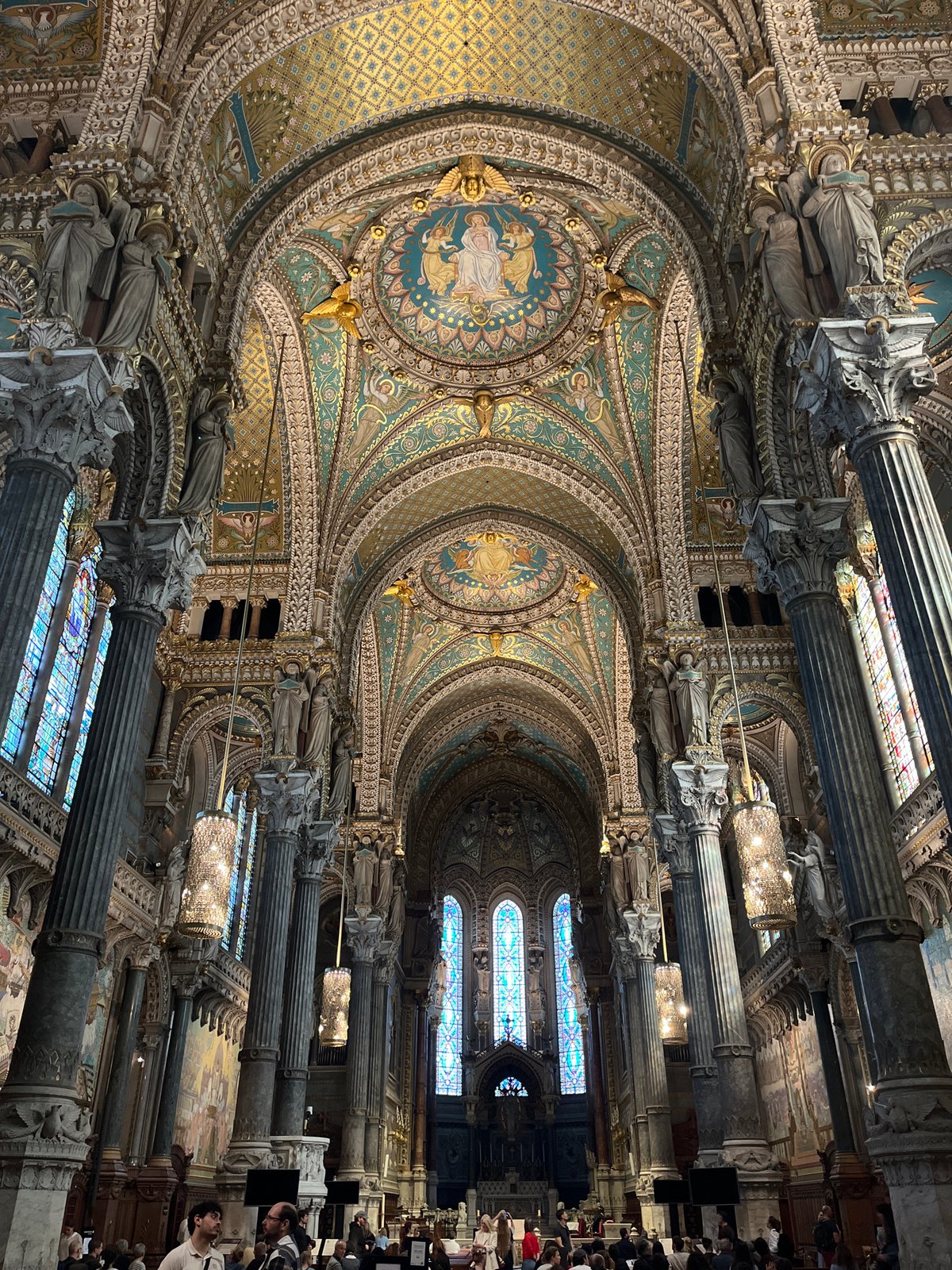 Visitor documents ornate interiors at Lyon's Notre-Dame de Fourvière basilica