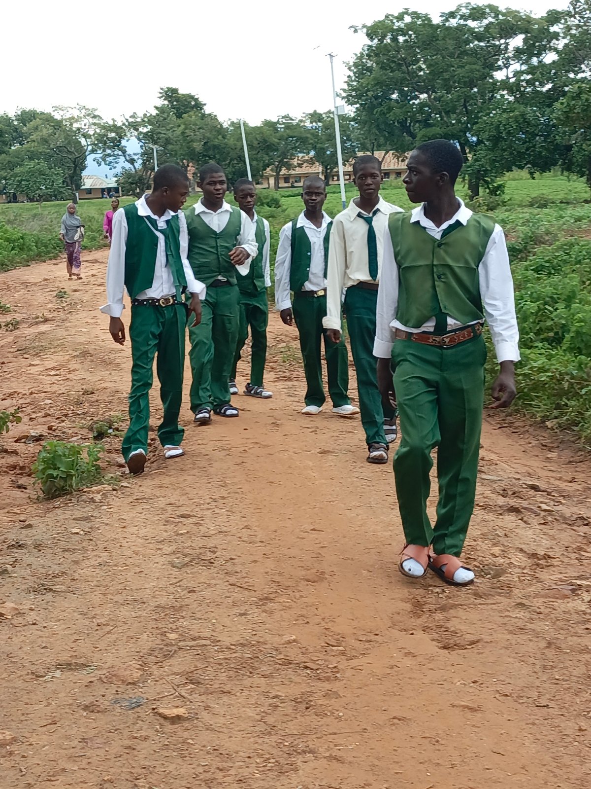 Students head to school along a dirt road in Akwanga, Nigeria