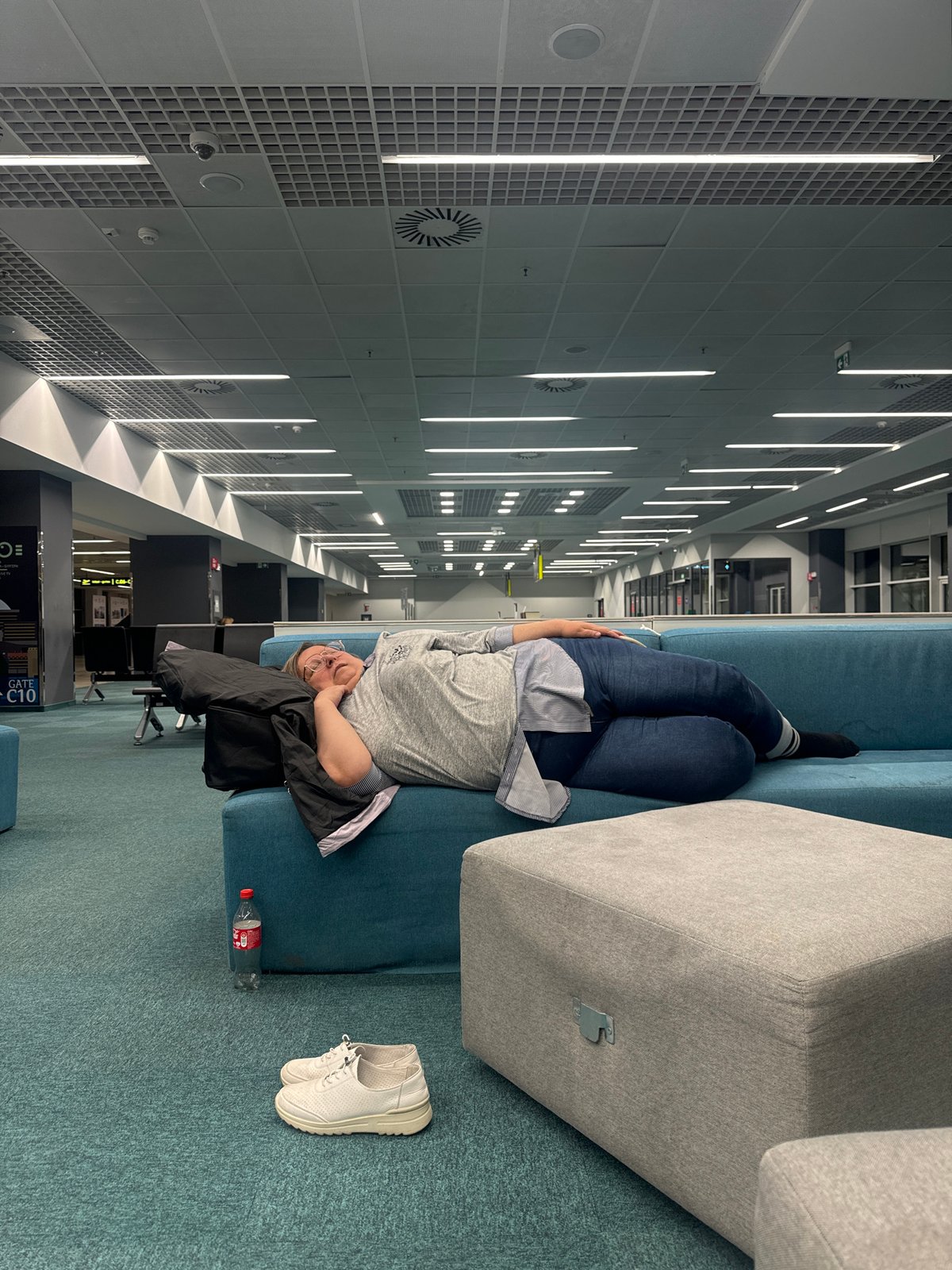 Person rests on sofa in modern building