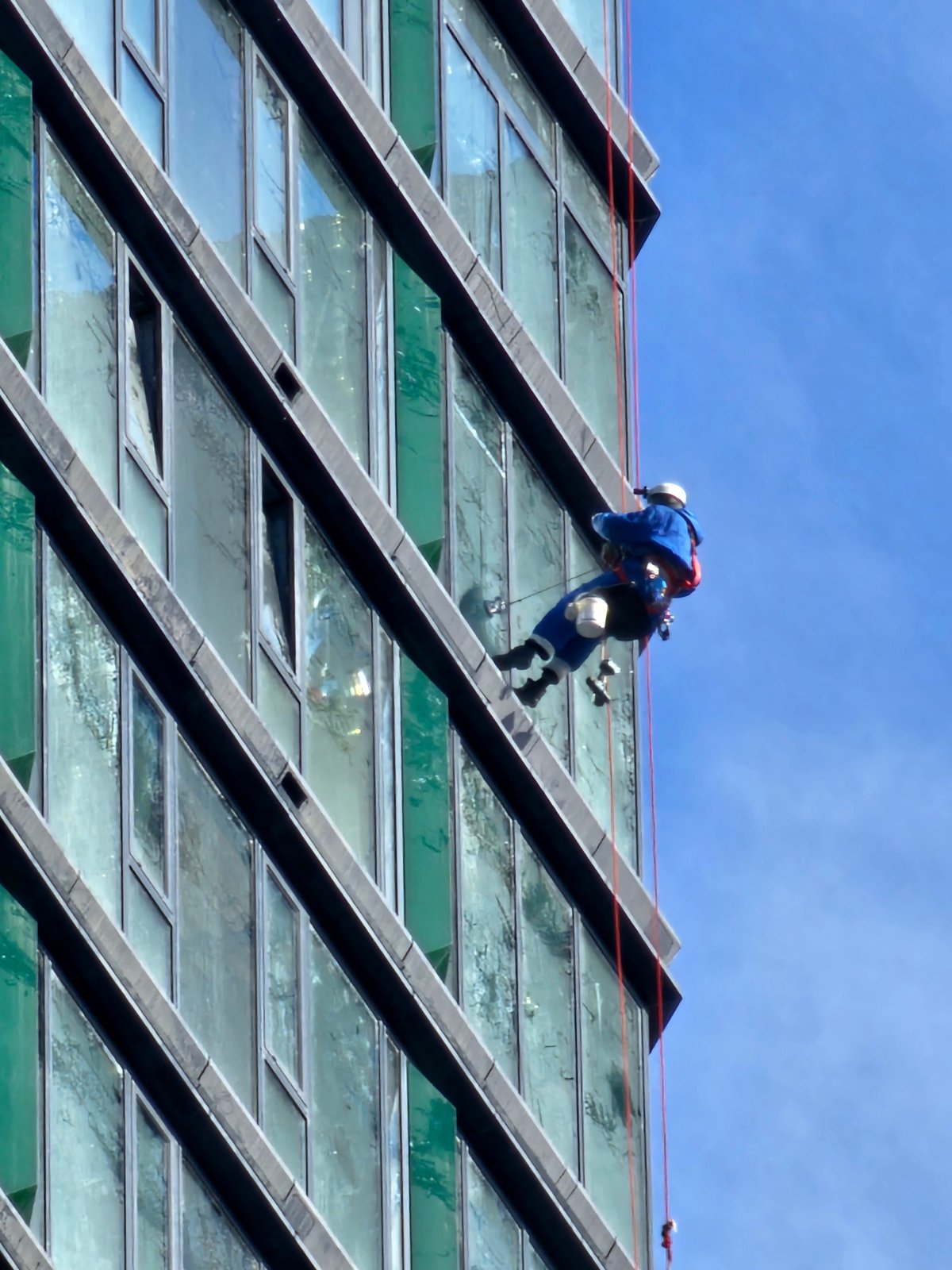 Window washer rappels down Moscow building during daytime