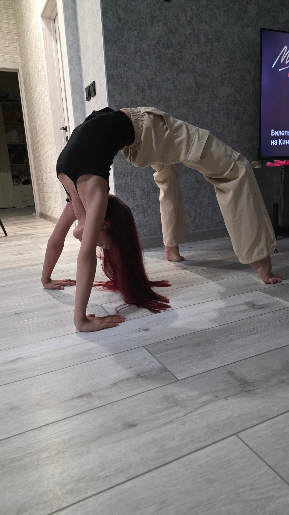 Woman practices yoga poses in Bulgakovo home