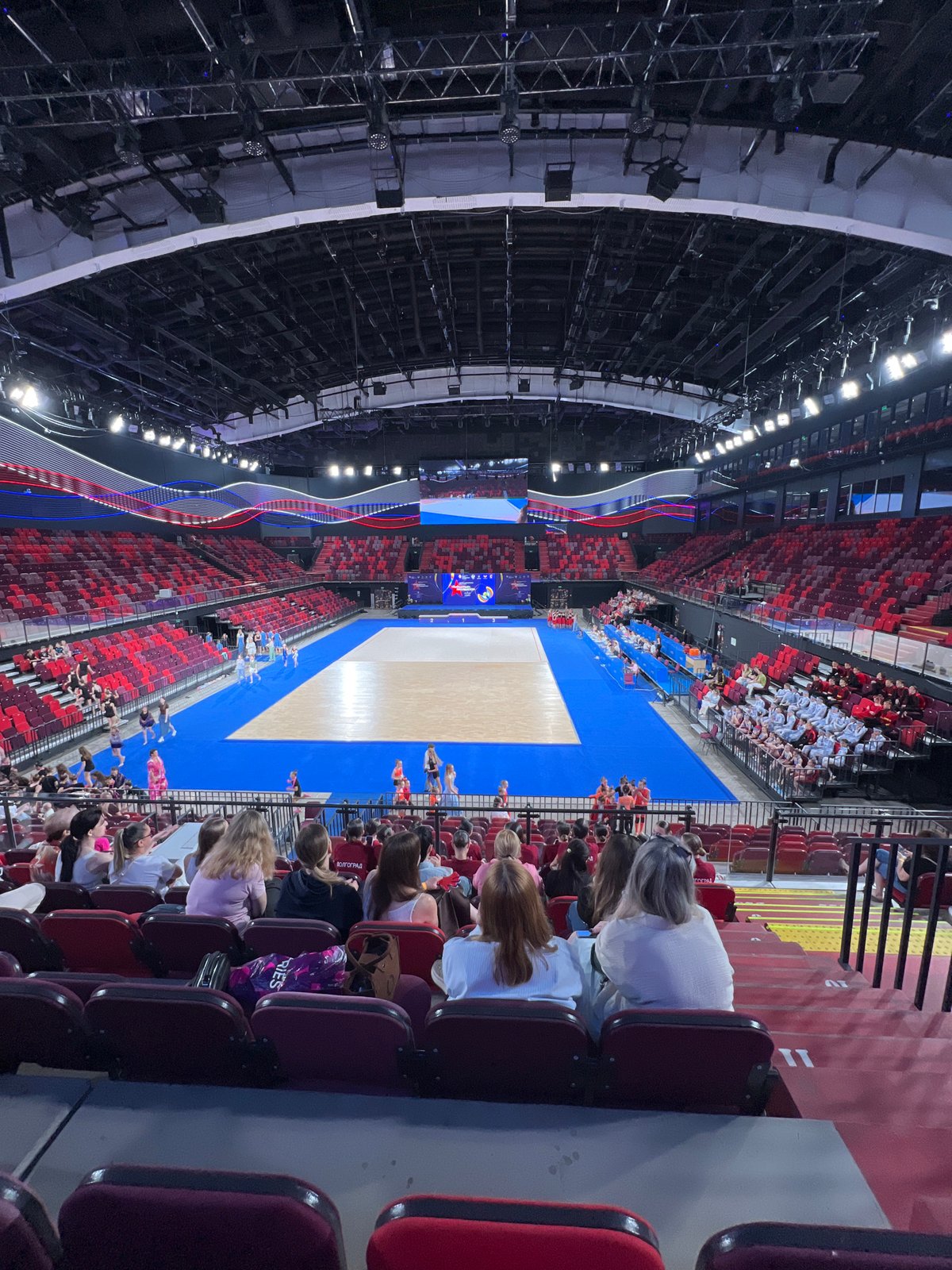 Young gymnasts perform synchronized routine in indoor arena