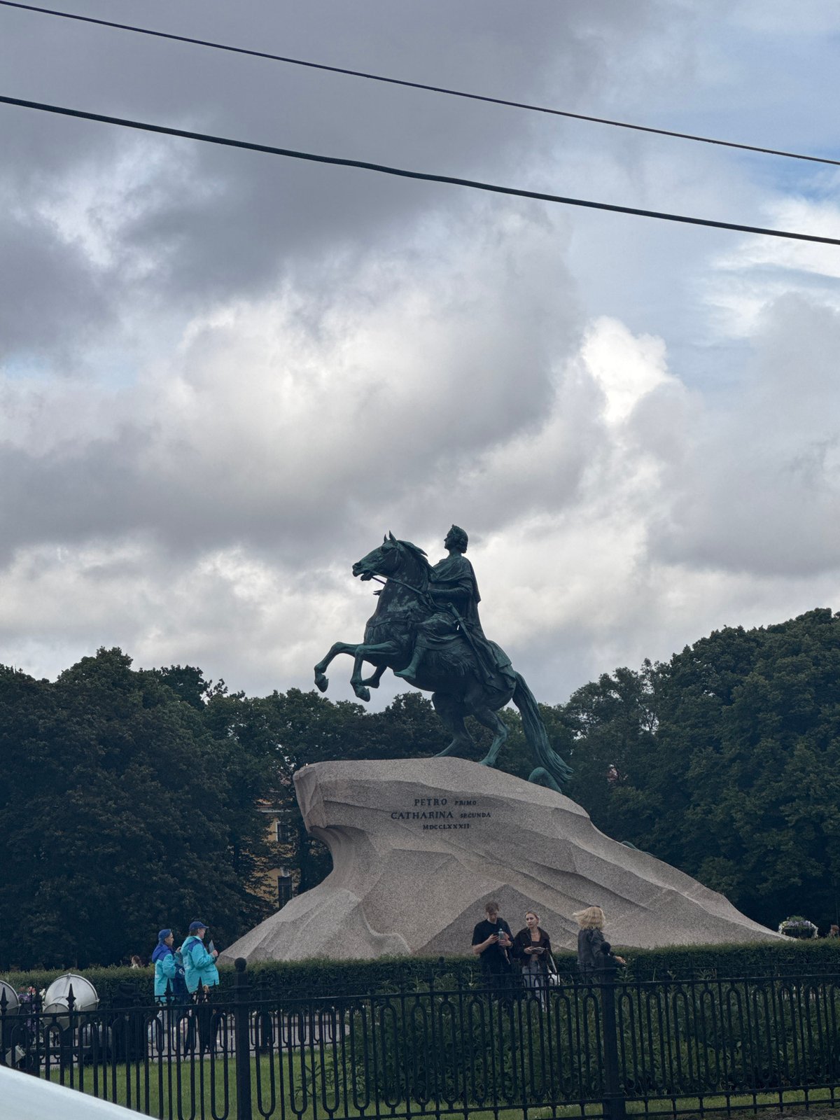 Cloudy day on a Russian city riverfront with bridge and statue