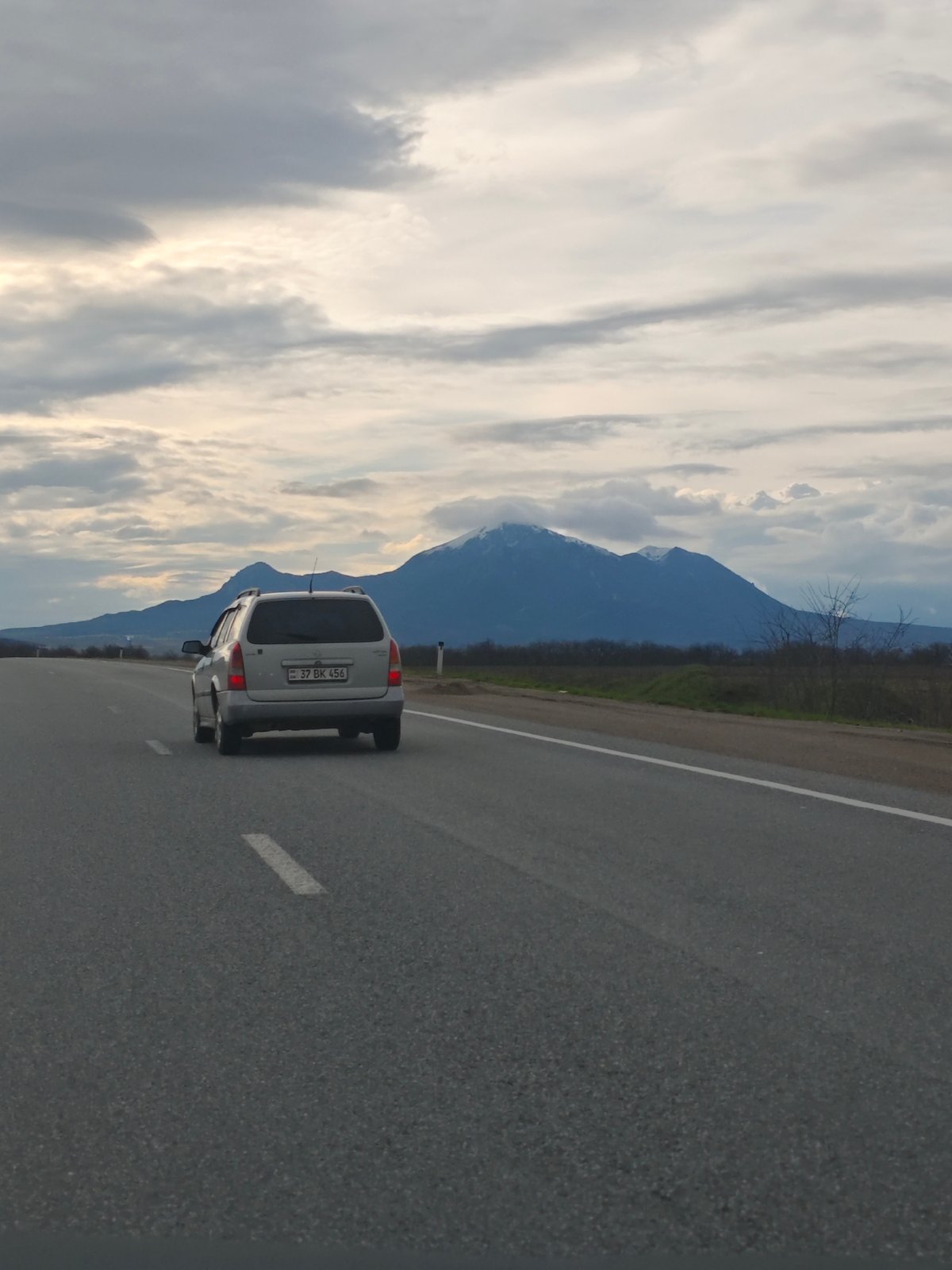 Silver station wagon travels rural road near Konstantinovskaya, Russia