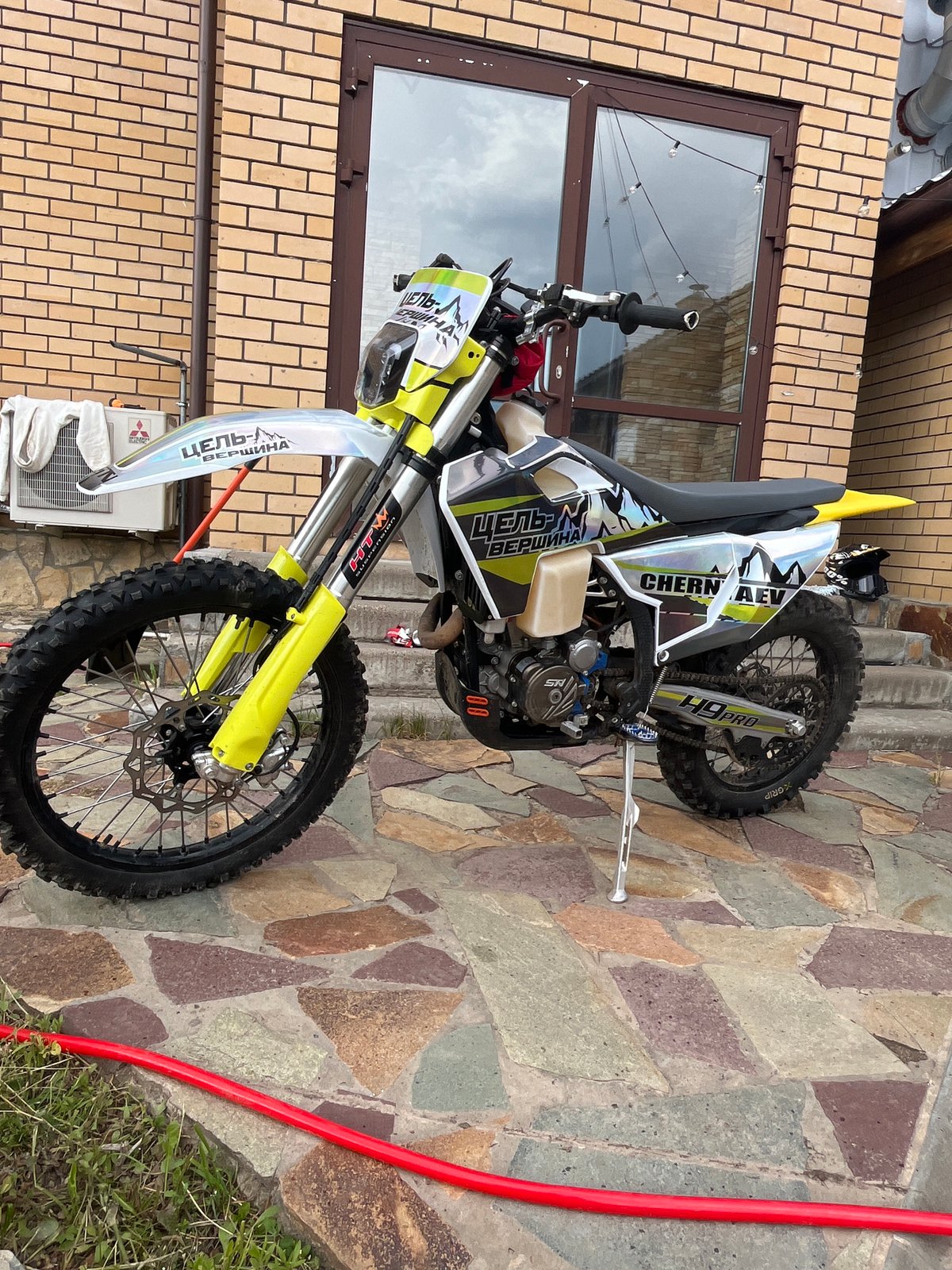Dirt bike documented in Russian residential backyard garden