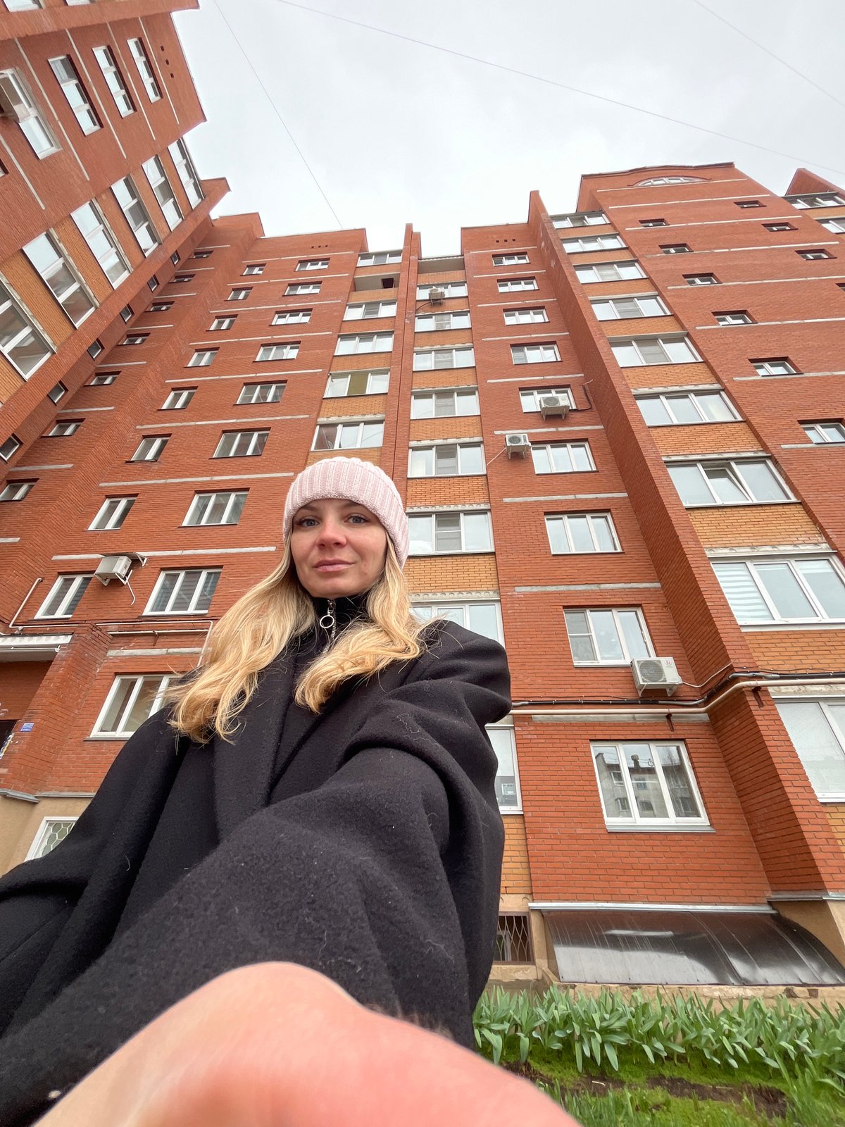 Woman takes selfies outside residential building in Chaikovsky