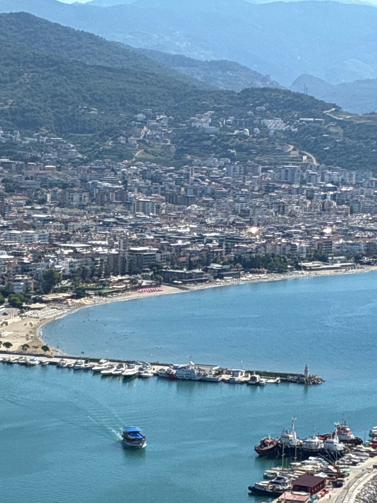 Alanya from above: castle ruins, harbor, and coastline on a summer morning