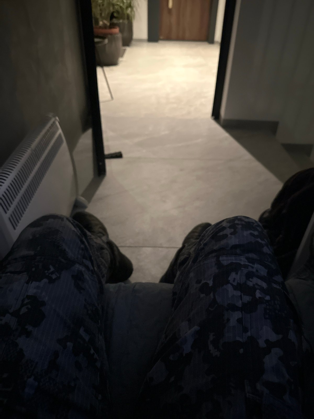 Person in camouflage sits on radiator in Sofia interior