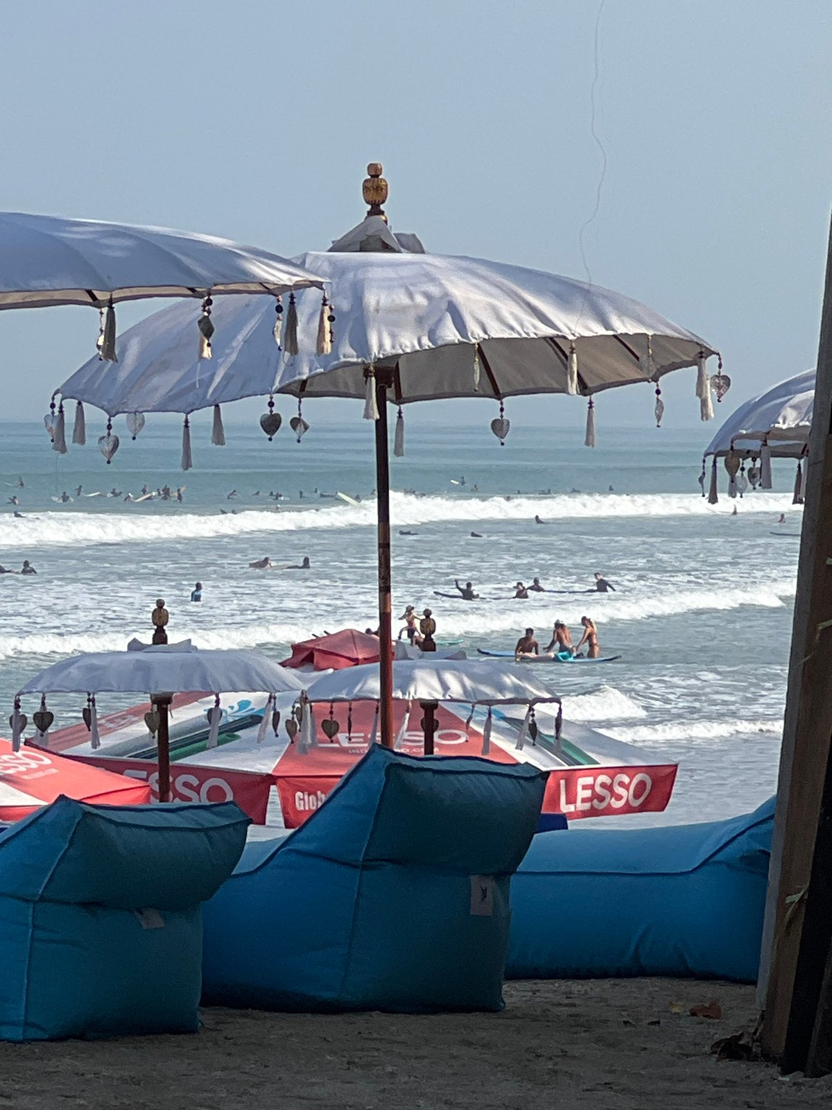 Busy morning session at Kuta Beach, surfers and crowds in the mix