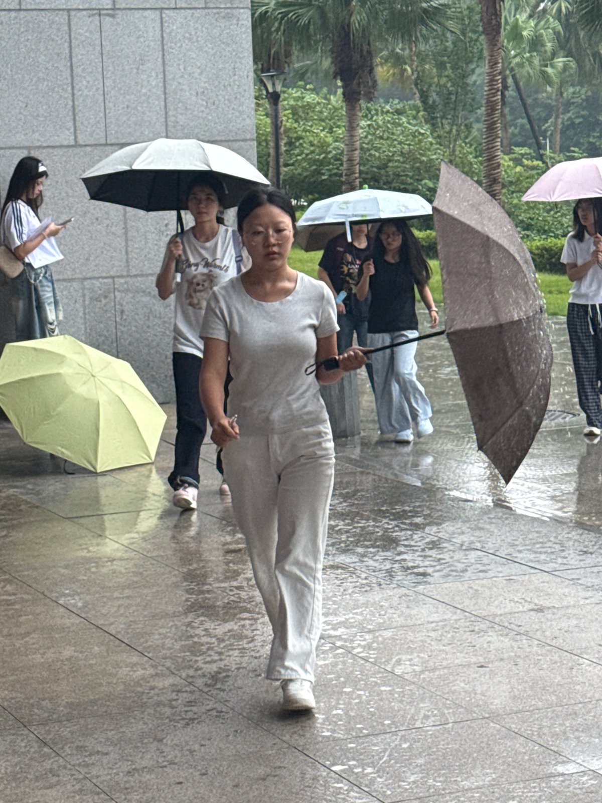 Rainy campus day in Jiangjin with outdoor crowds and indoor presentations.