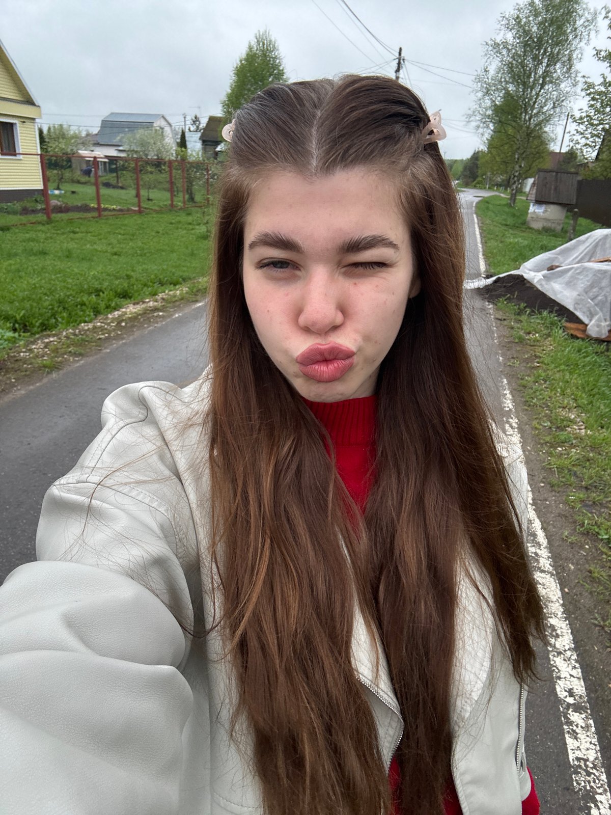 Woman takes selfies on wet road in Mещёры