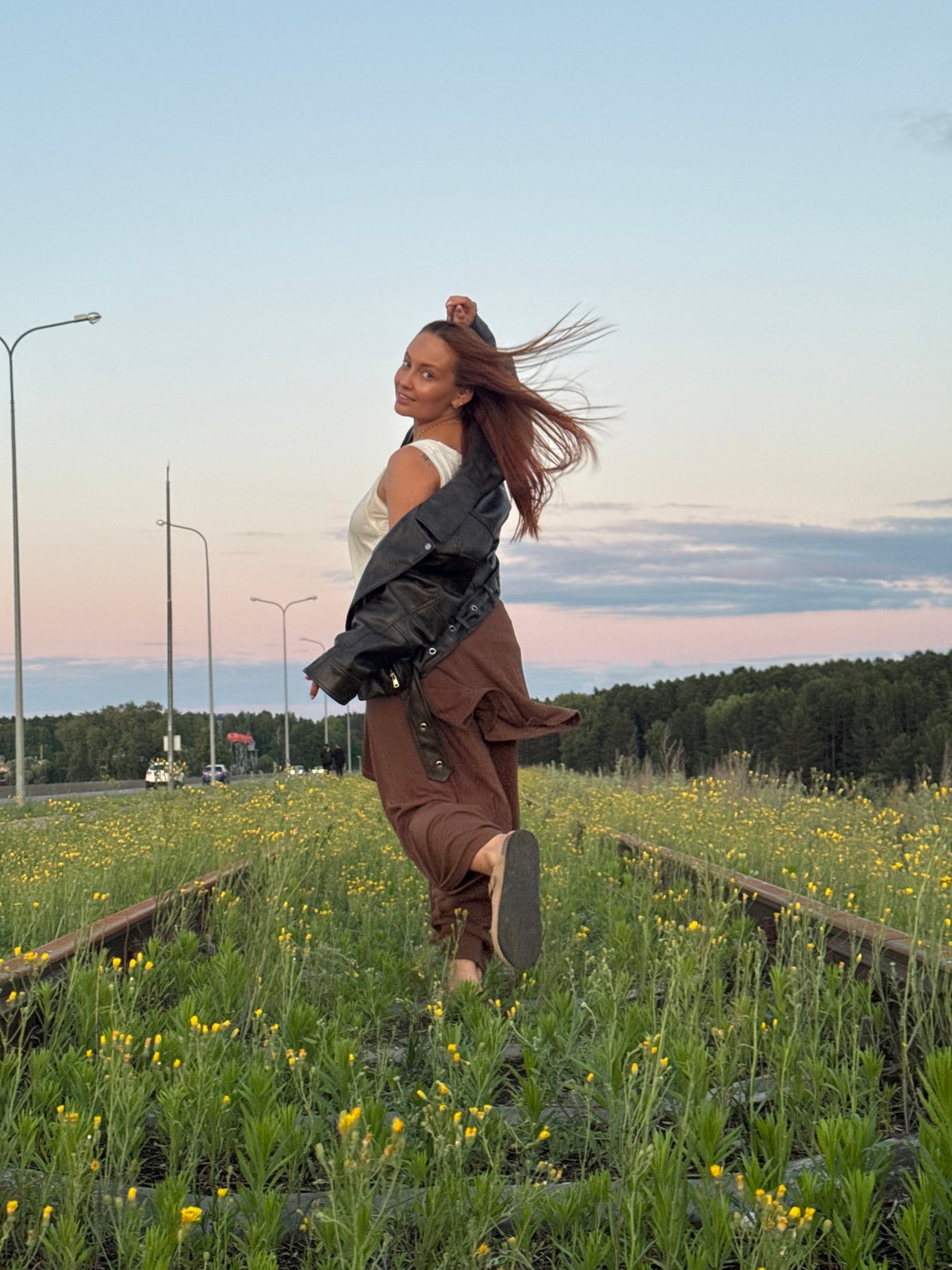 Woman photographs sunset moments along abandoned tracks in Chaikovsky