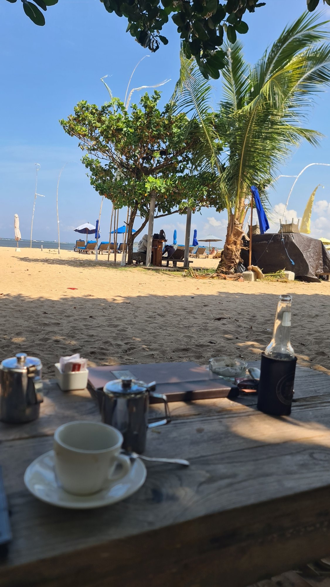 A Bali beach morning: jukung boats, kite surfers, and beach loungers