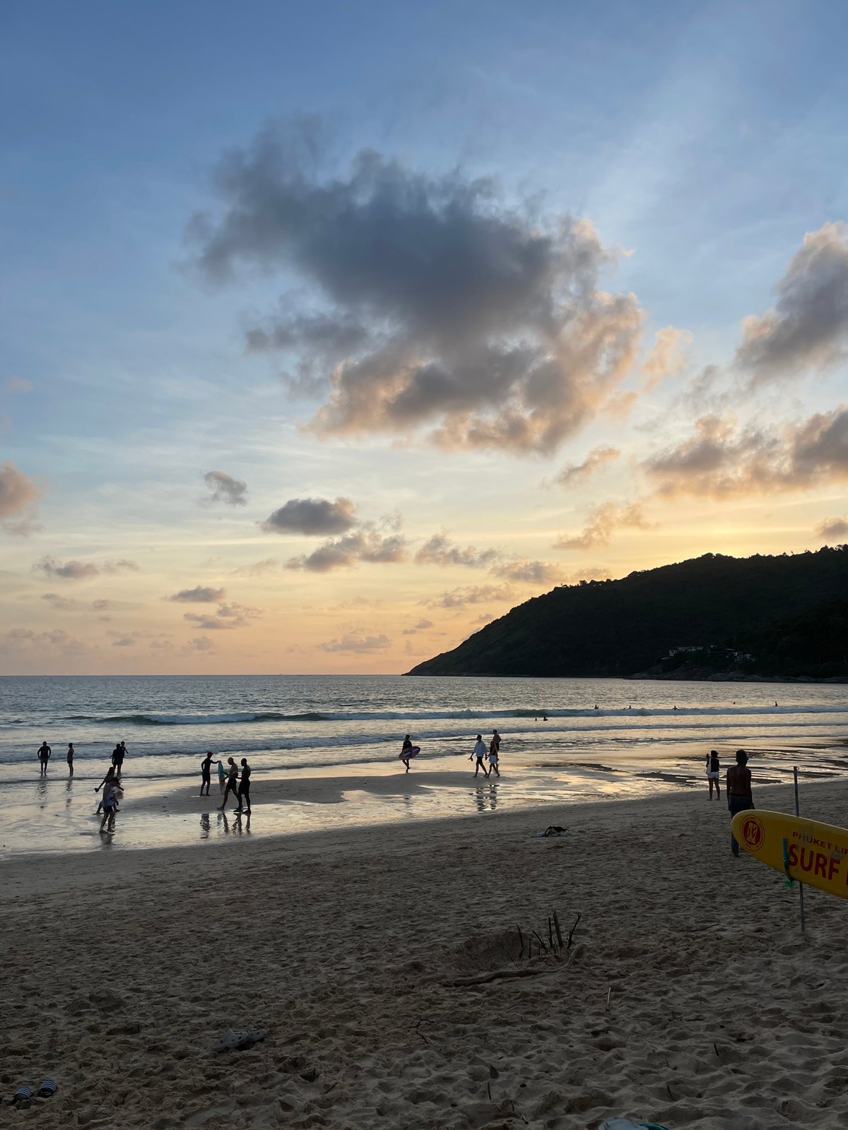 Golden hour on Rawai Beach, palm silhouettes and a warm sky.