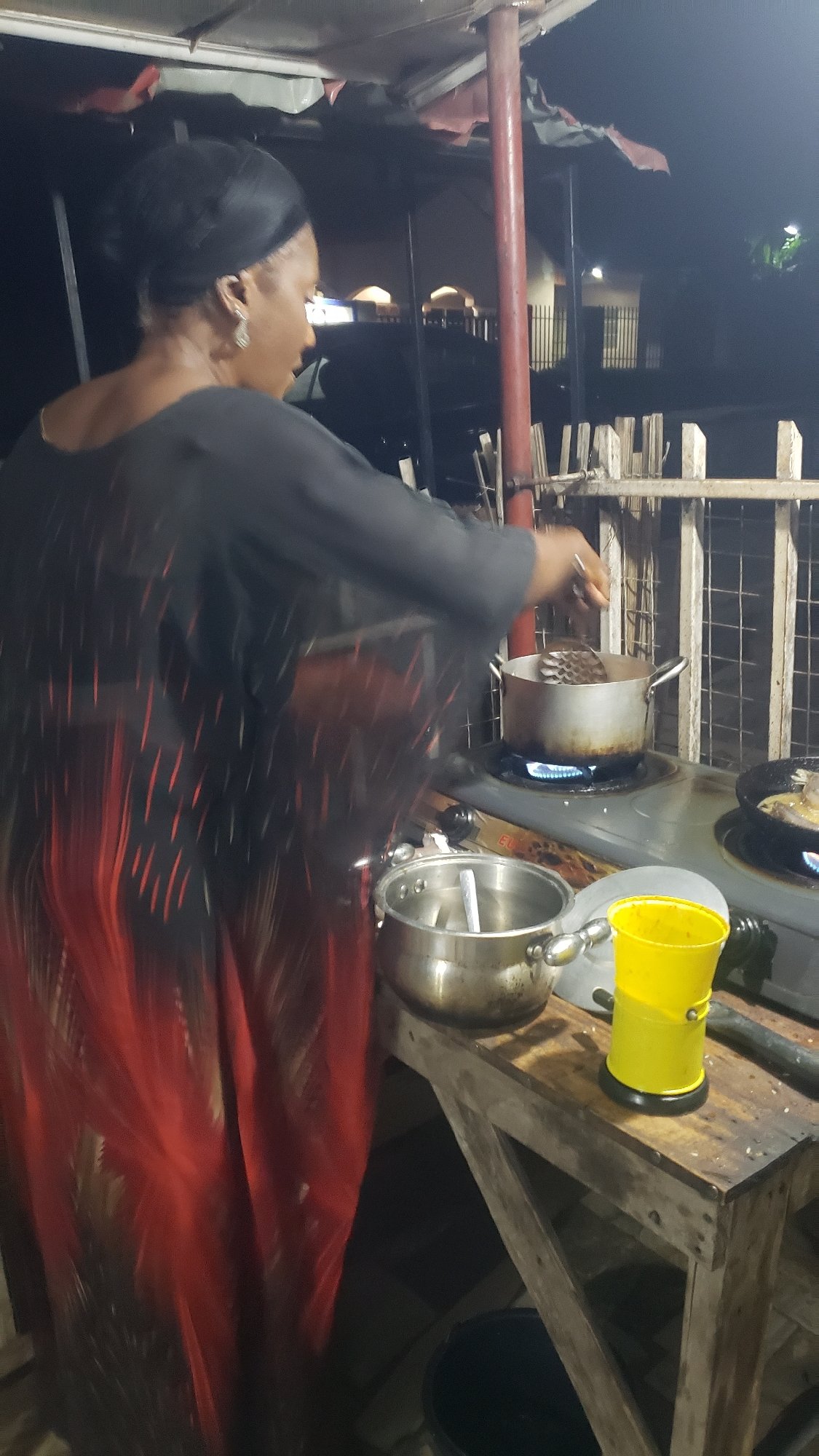 Night street food stall cooking fish and rice in Narayi