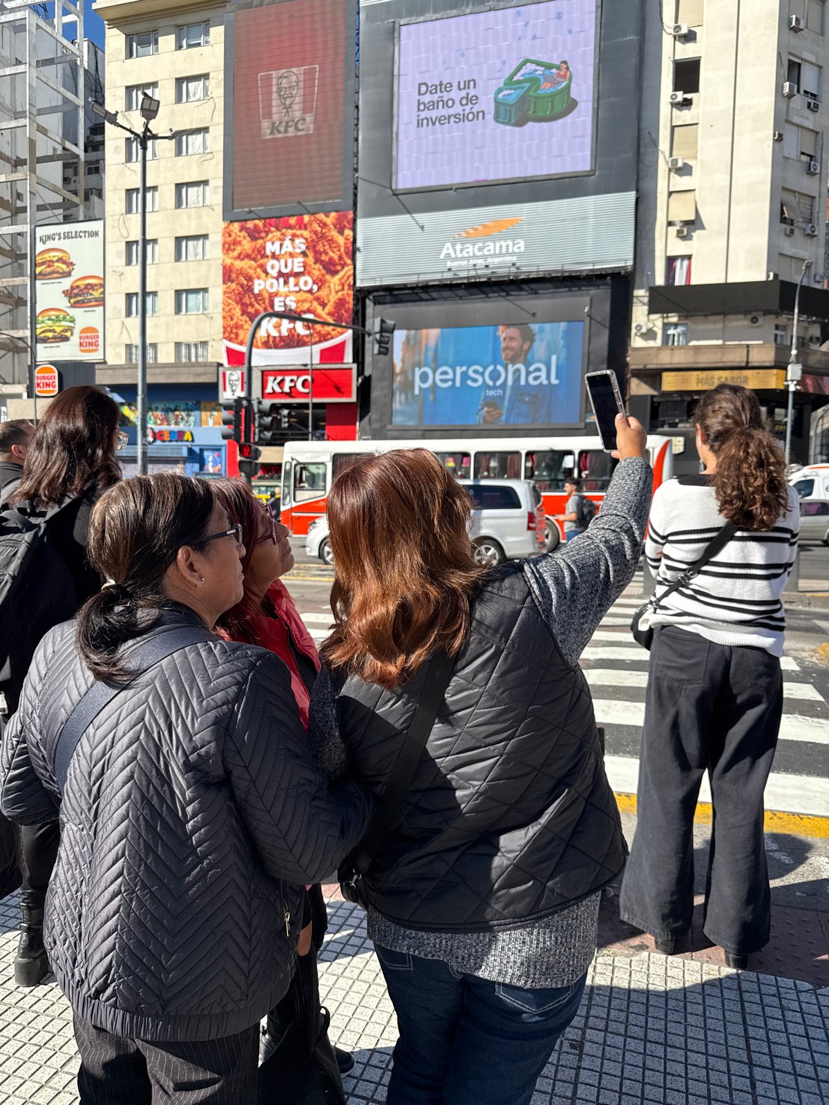 Daily life continues around Buenos Aires Obelisco on sunny afternoon