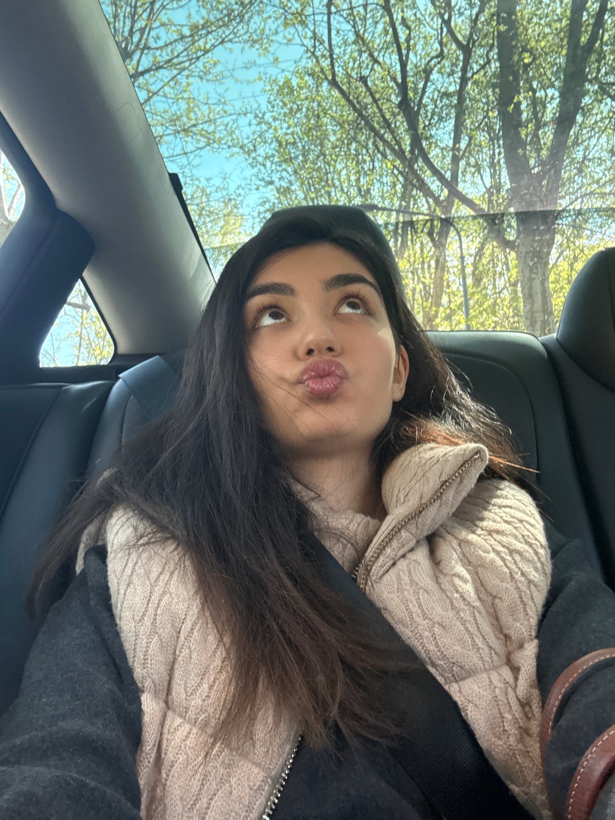 Woman makes kissing face in car passenger seat, Milan