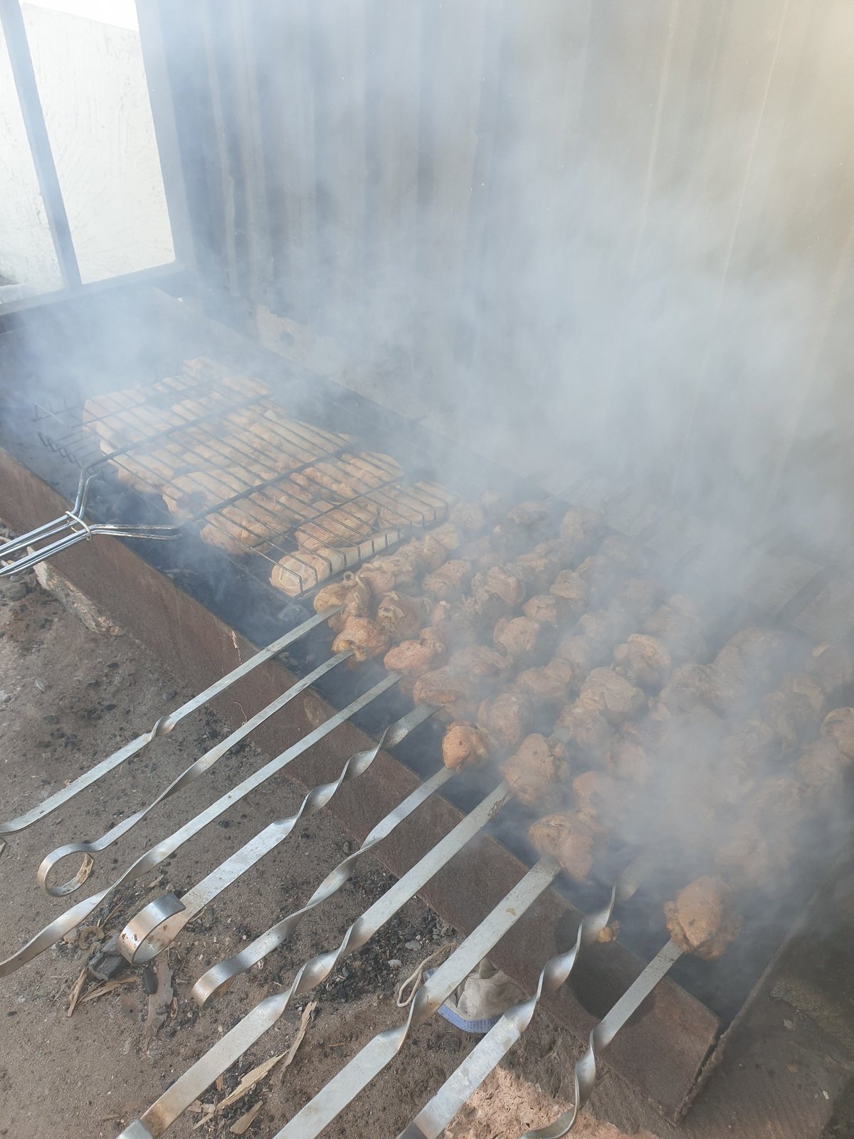Outdoor coal grilling with skewers in Kuryk, Kazakhstan