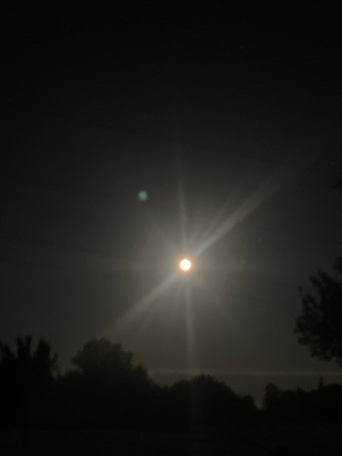 Bright nighttime light source illuminates unknown location sky