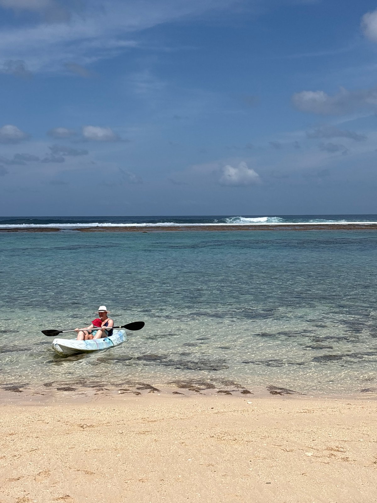 Clear morning at a Kuta Selatan beach with surf and kayaking