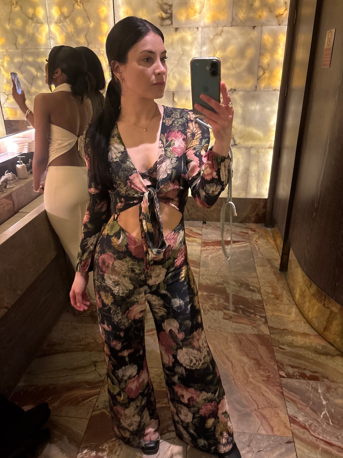 Women photograph themselves in London bathroom mirror