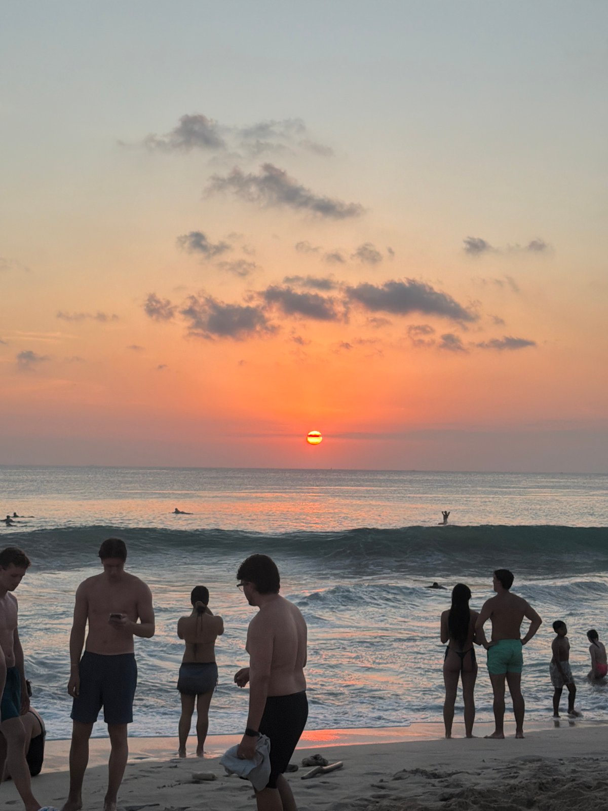 Sunset crowds gather on Kuta Selatan beach for surf and volleyball