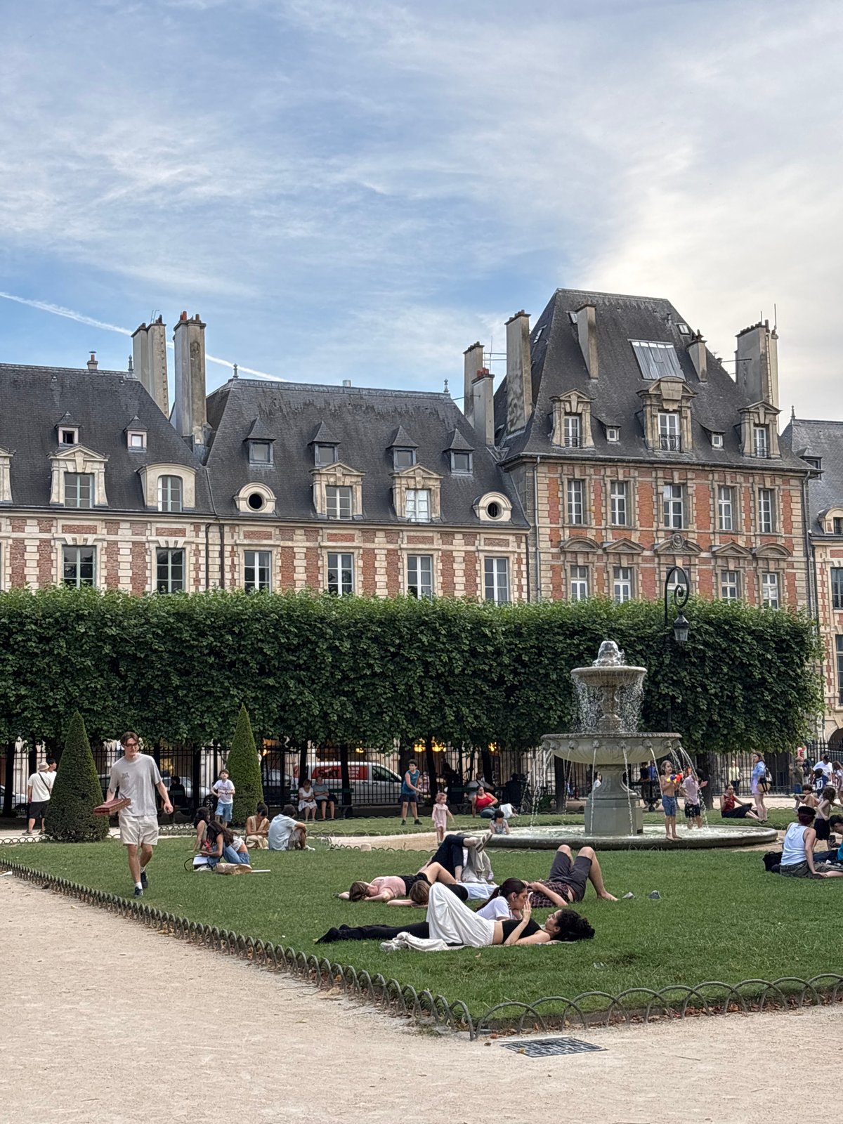 Locals and visitors unwind at Place des Vosges on a June afternoon