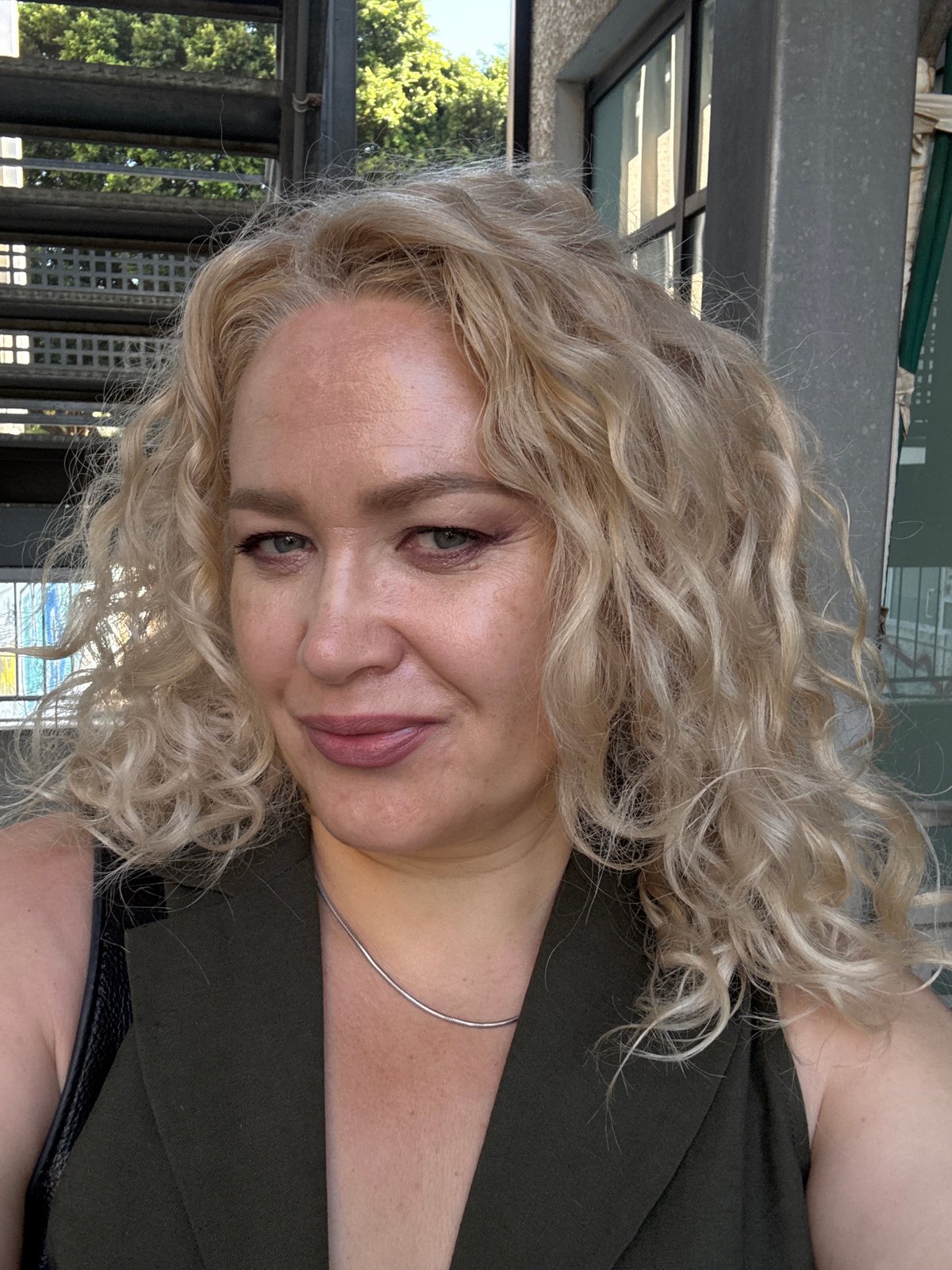Outdoor selfie in Tel Aviv with urban greenery backdrop
