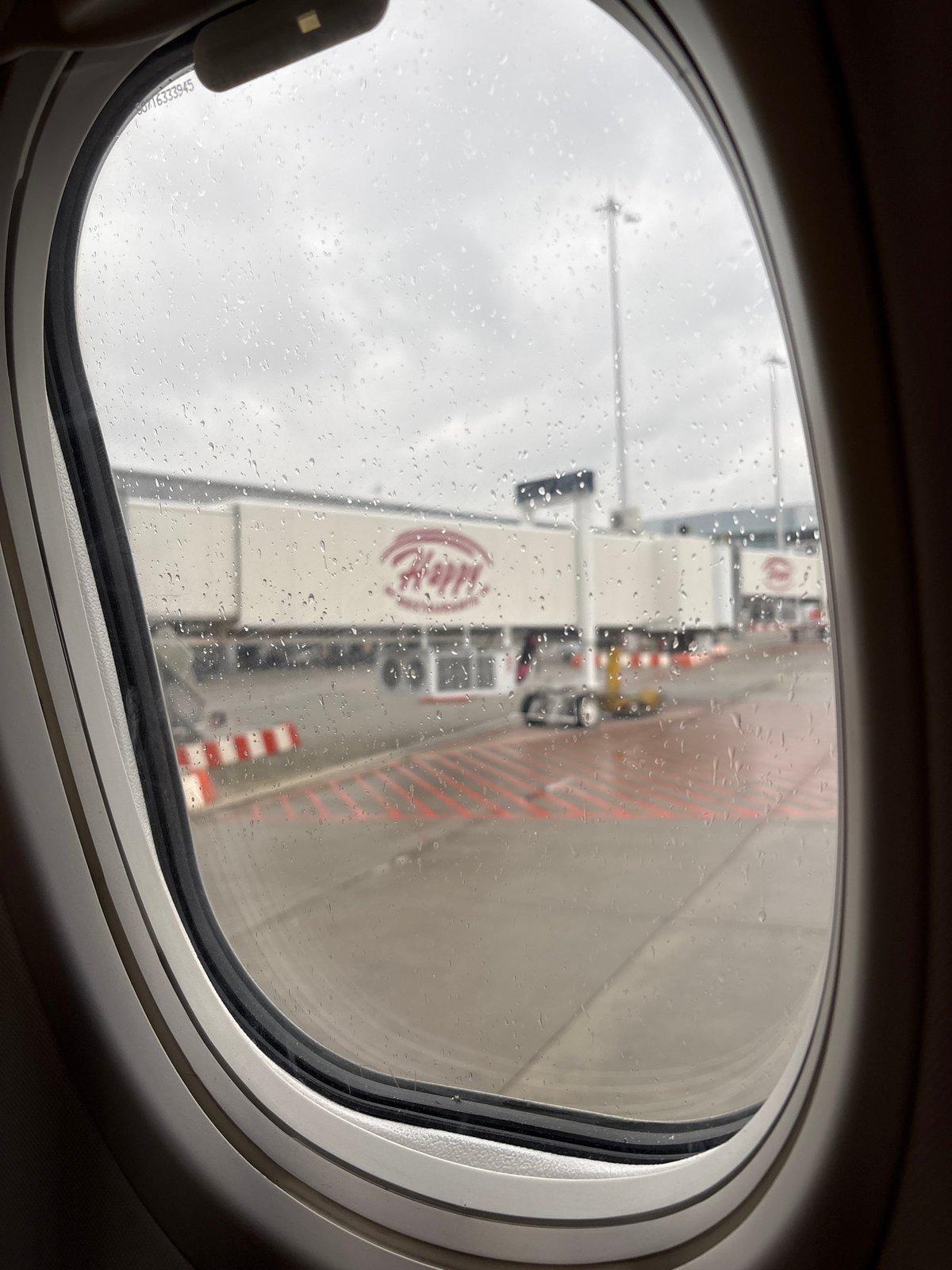 Rainy airport view captured through airplane window in Sofia