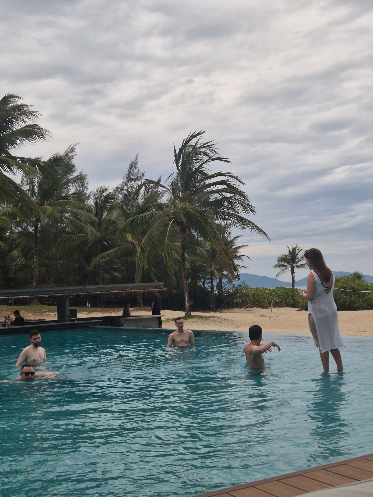 Poolside drinks and beach views at a Hoi An resort