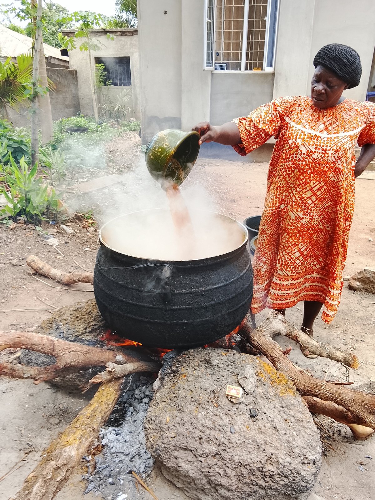 Woman cooks over open fire outdoors