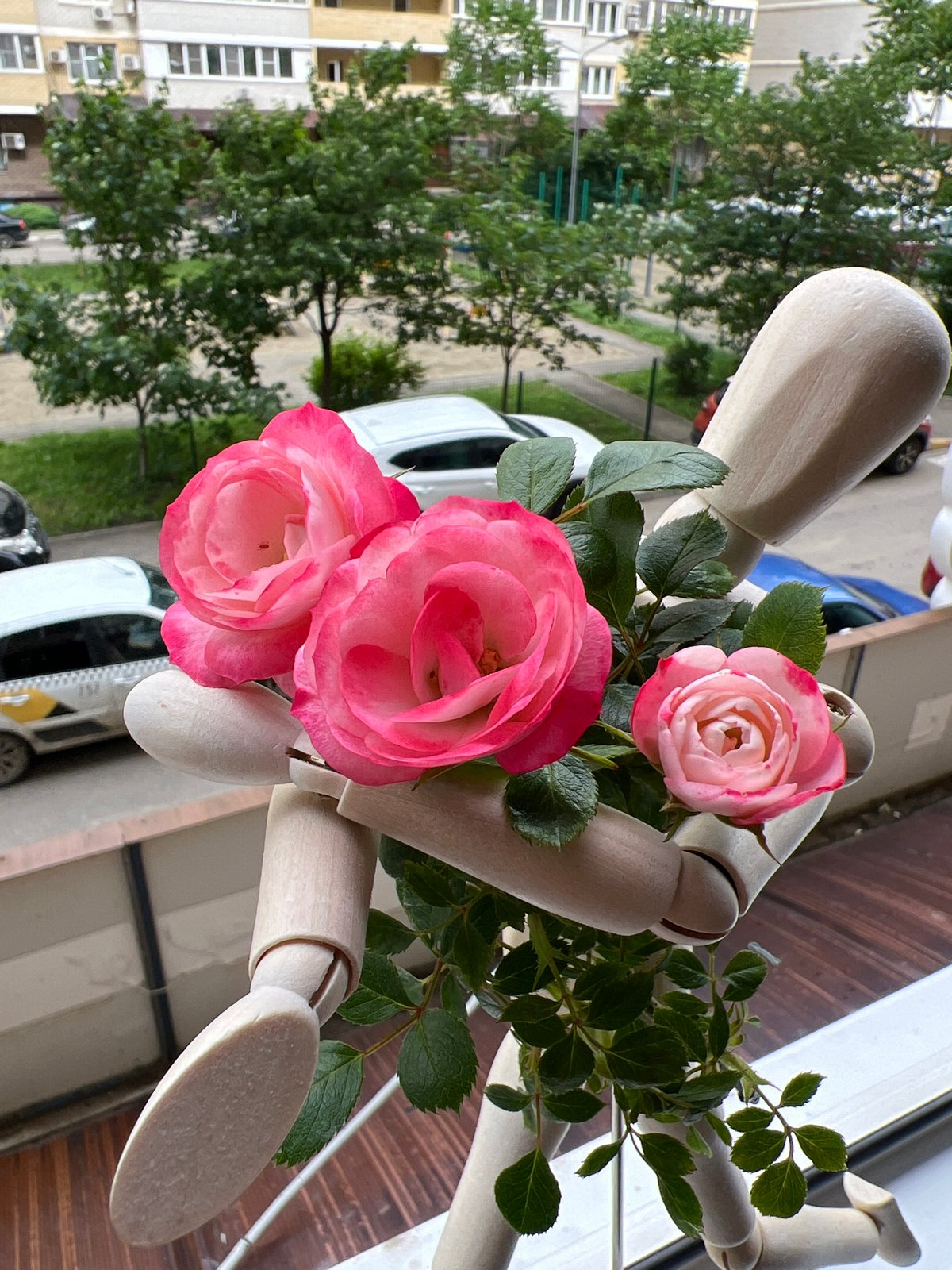 Artist documents wooden mannequin with roses in Krasnodar balcony session