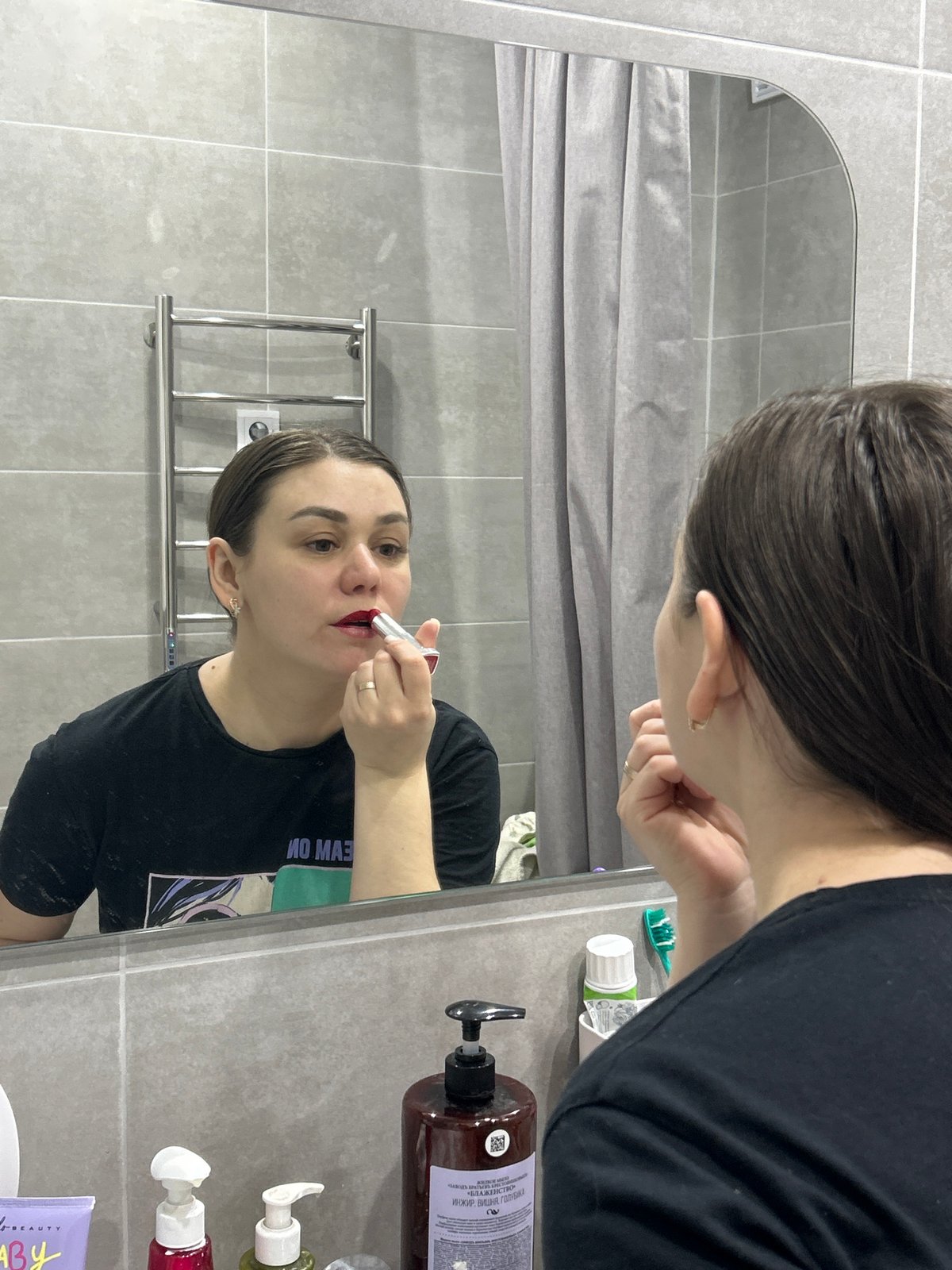 Woman applies makeup in Chaikovsky bathroom, shows manicured nails