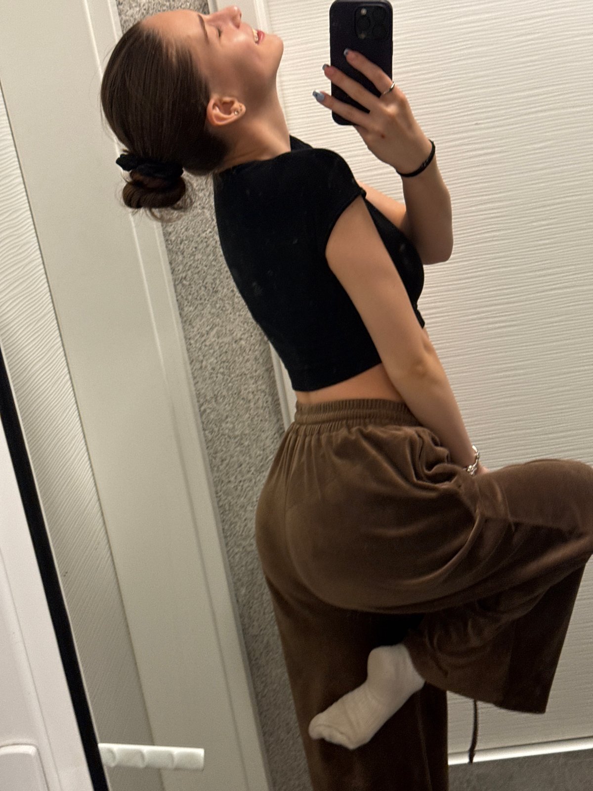 Woman takes bathroom mirror selfies in Sofia apartment