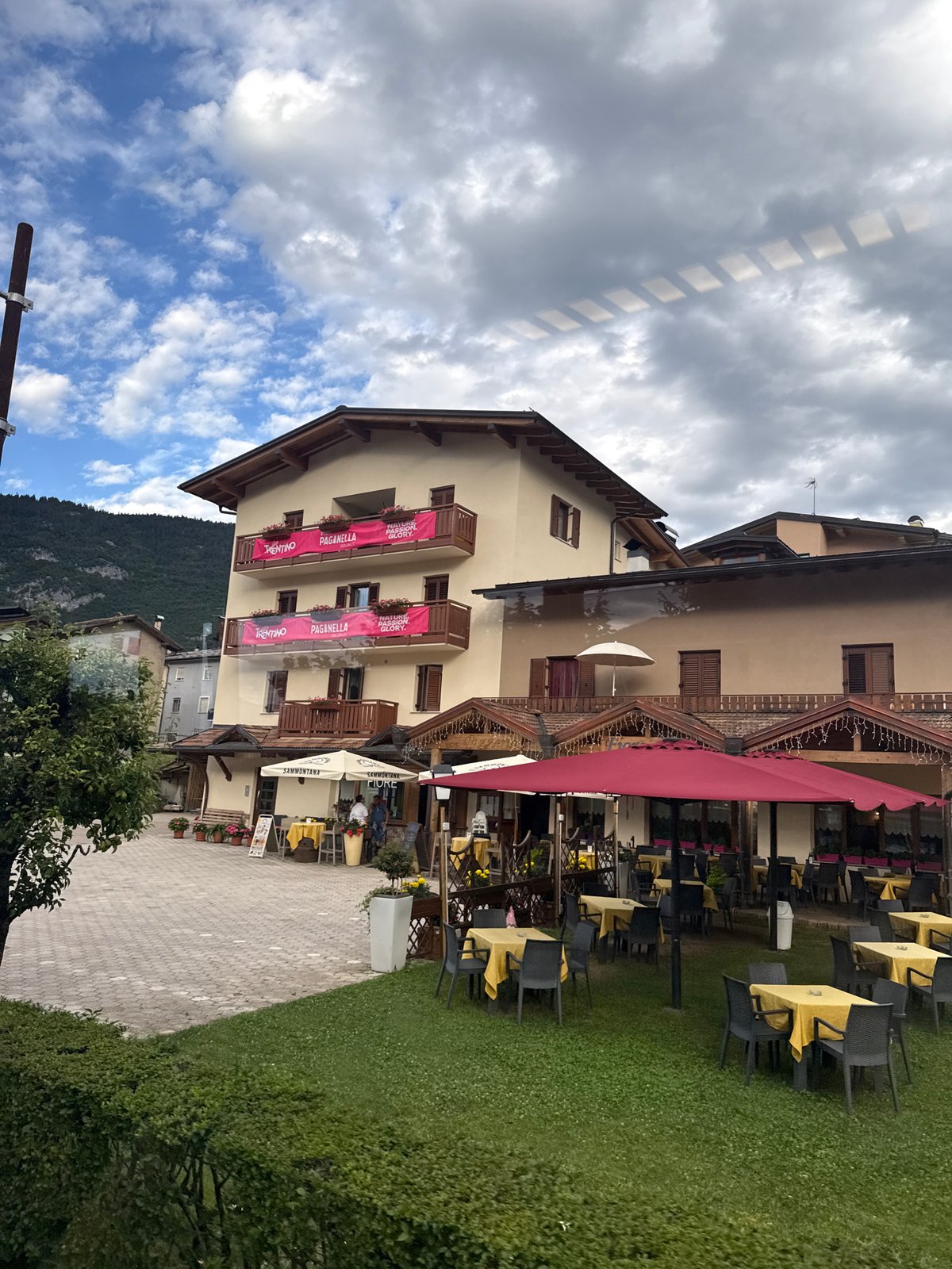 Alpine street scene in Cavedago with dining terrace and traditional facades