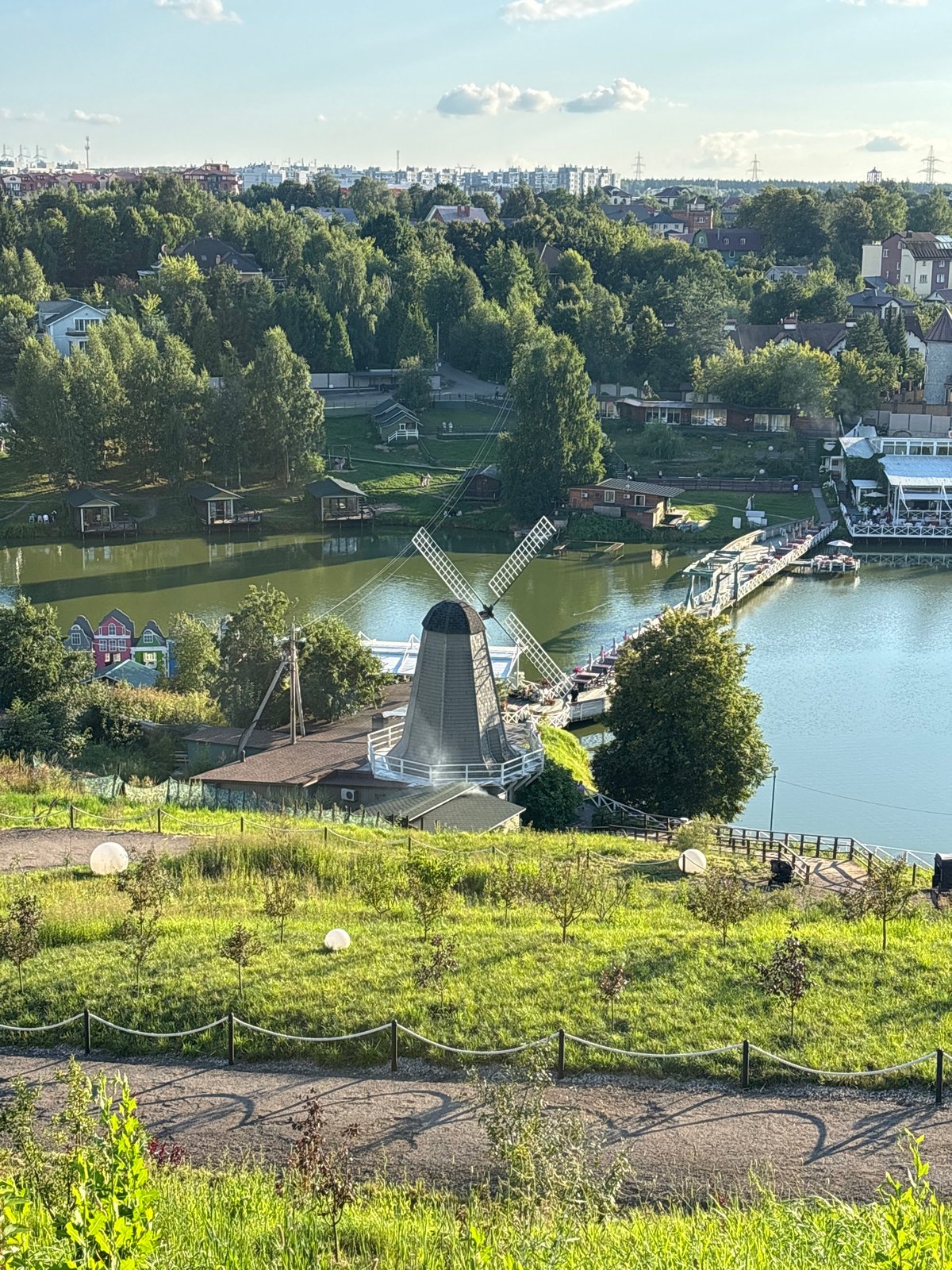 Romashkovo park: windmill, lakefront boats, and roaming animals