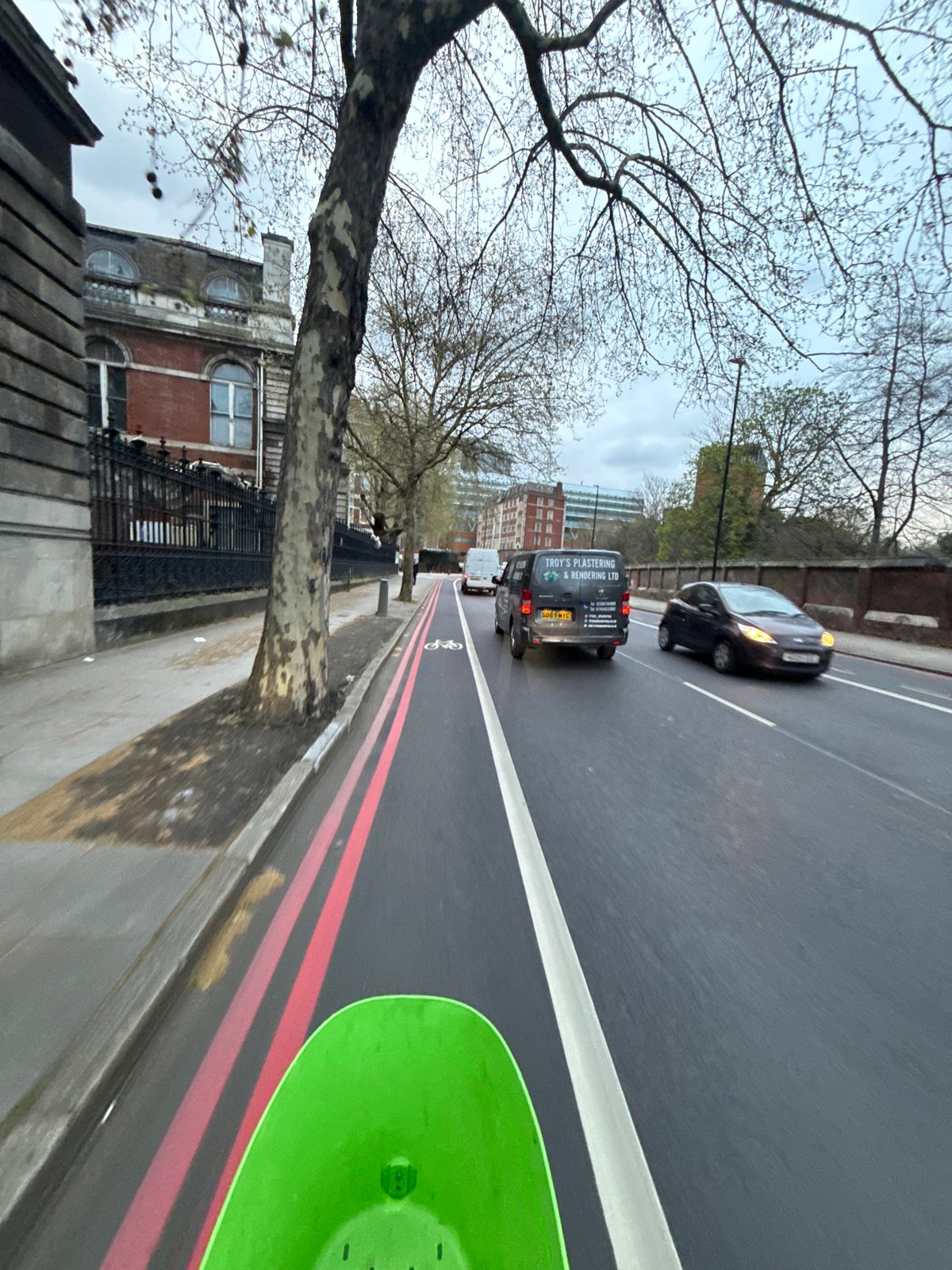 London street scene shows traffic and trees