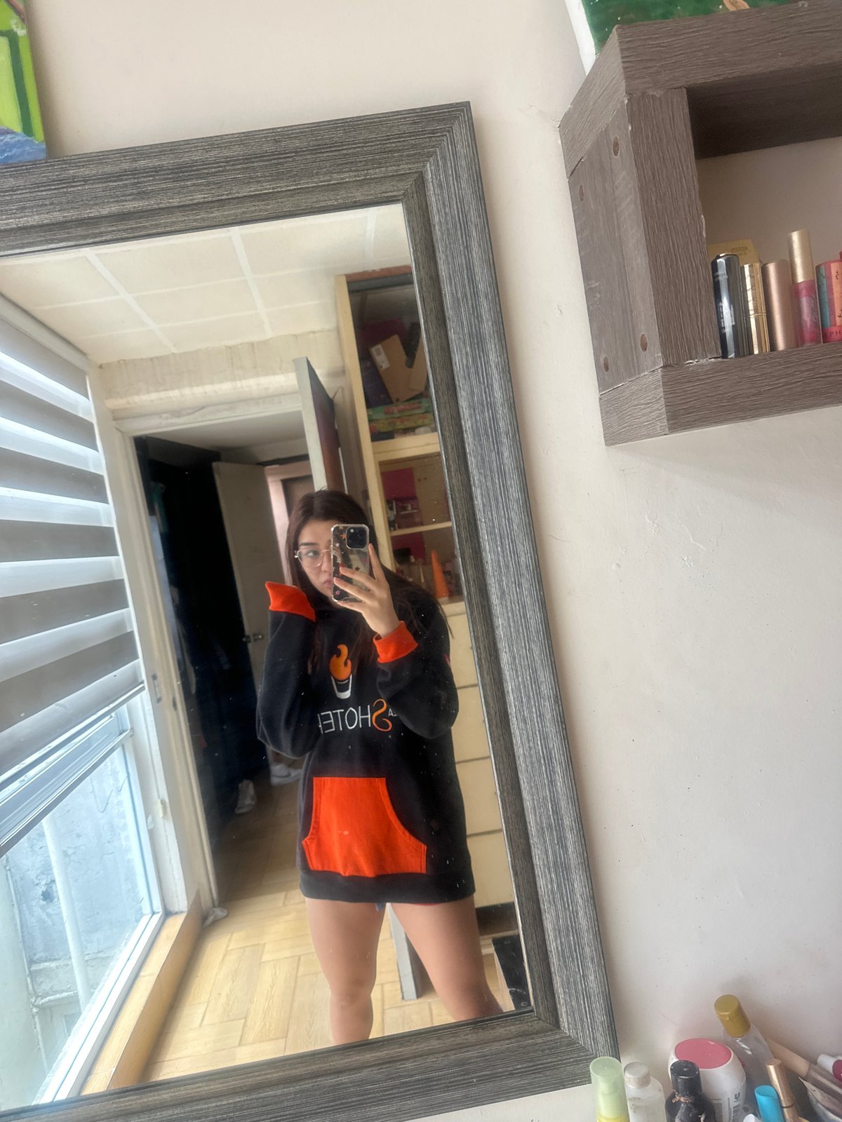 Mirror selfie in a Puebla bedroom, black hoodie with flame graphic.