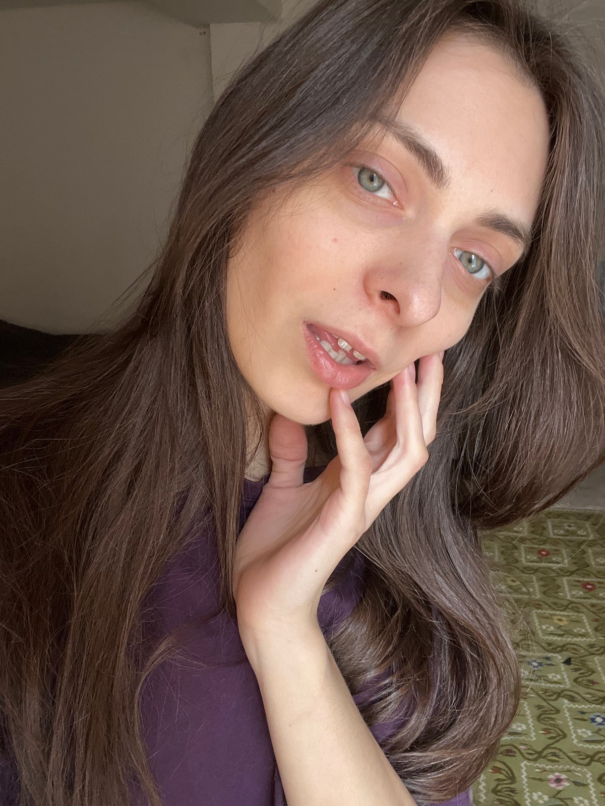 Woman takes selfies in purple shirt, Krasnoyarsk morning