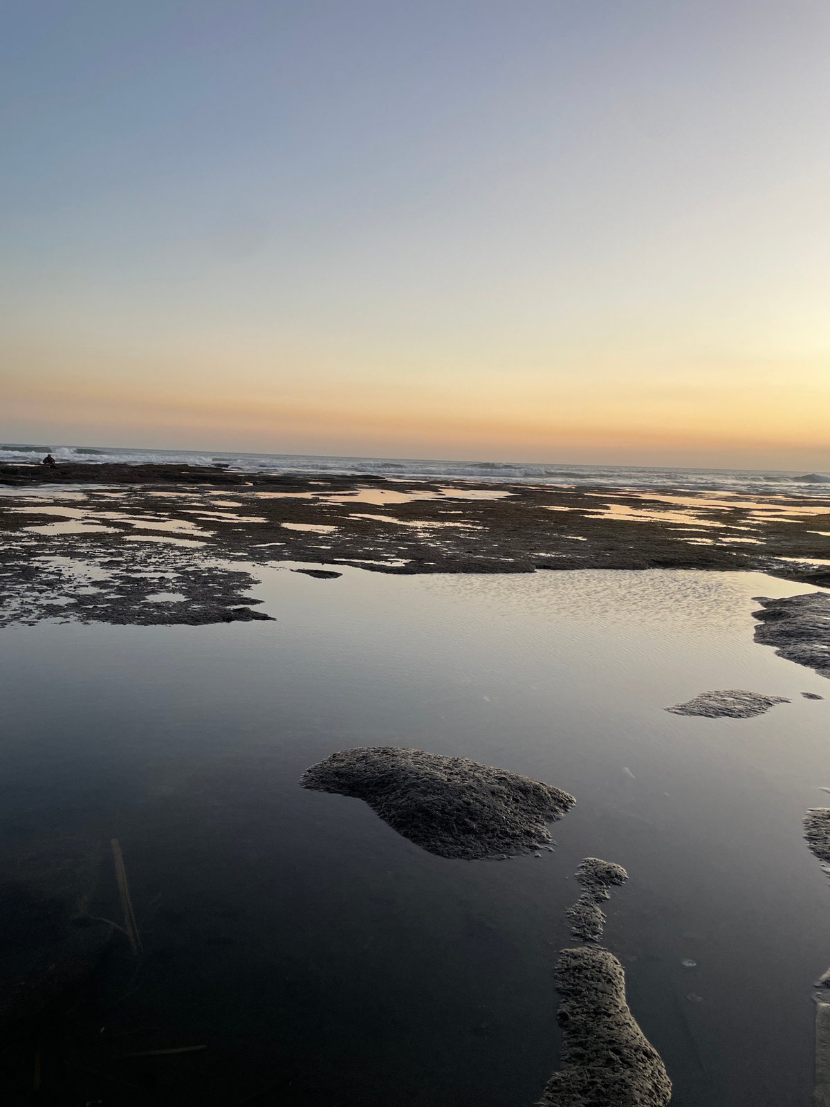 Sunset over a rocky beach in Kediri, Indonesia