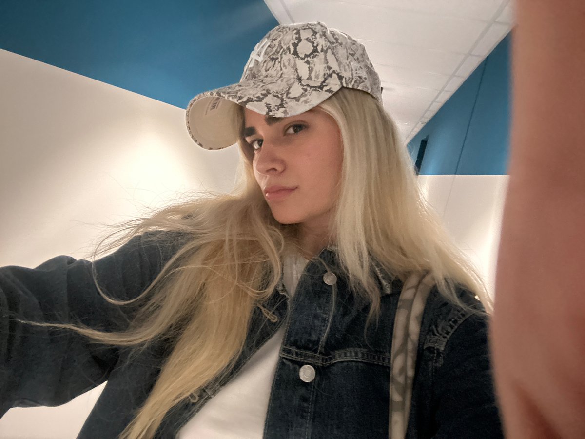 Woman in snakeskin cap photographed in Novate Milanese bathroom