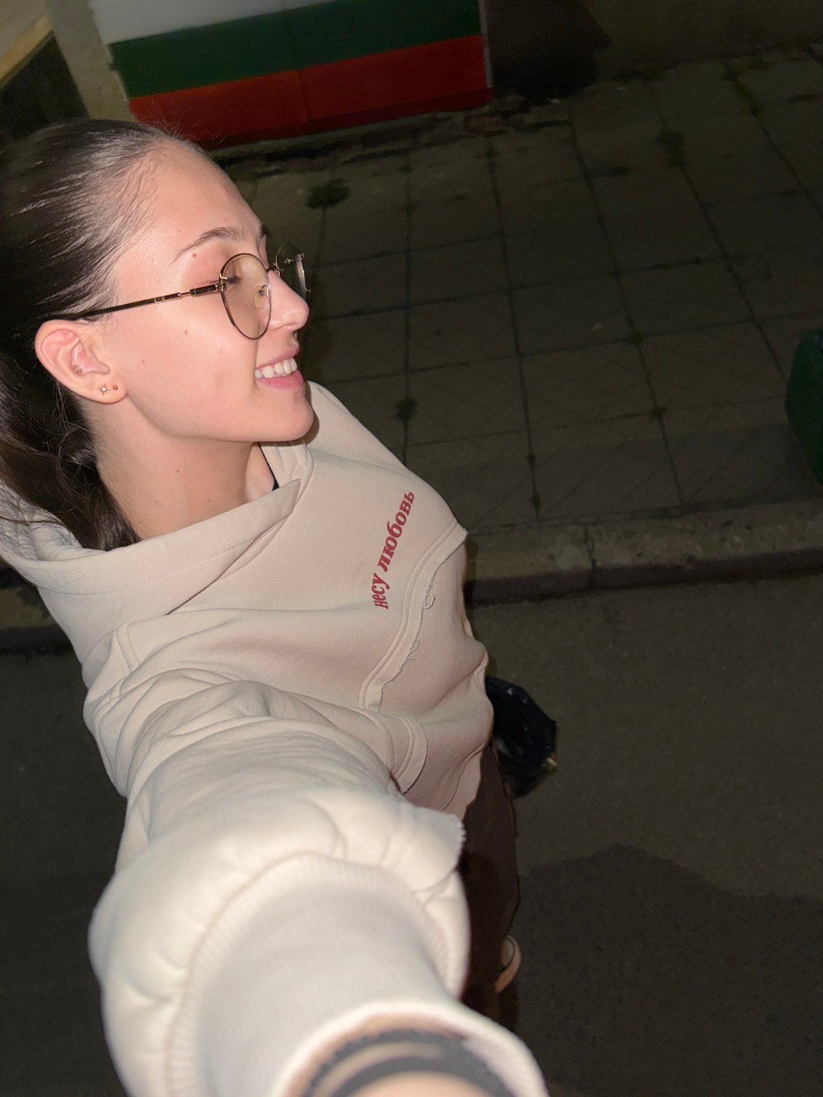 Woman takes nighttime selfie while walking Sofia streets