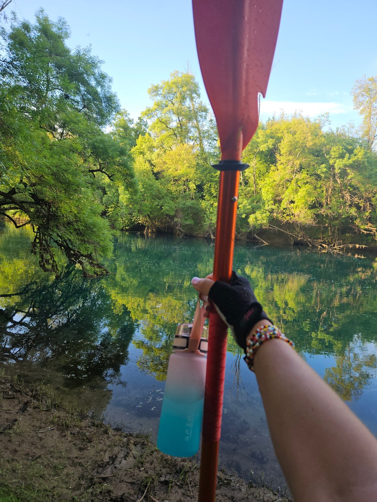 Kayaker spotted on wooded riverbank during afternoon paddle trip