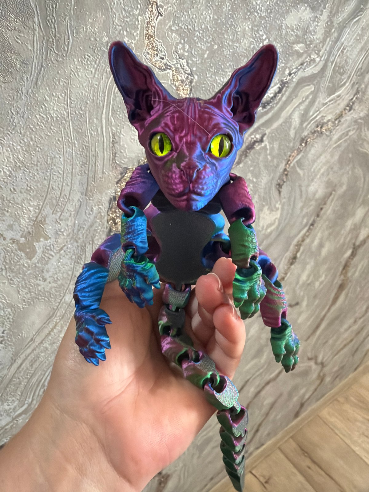 3D printed articulated cat figurines shown up close in hand