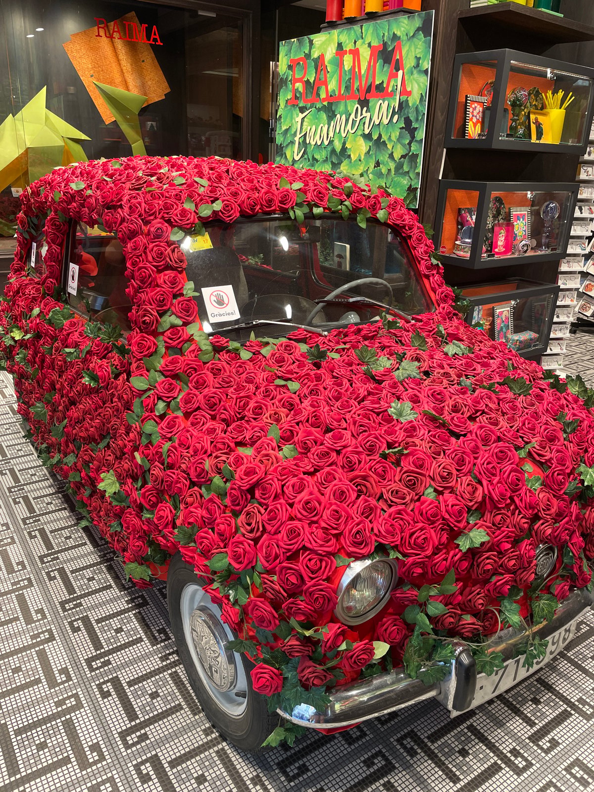 Rose-covered vintage Fiat 500 art installation displayed in Barcelona