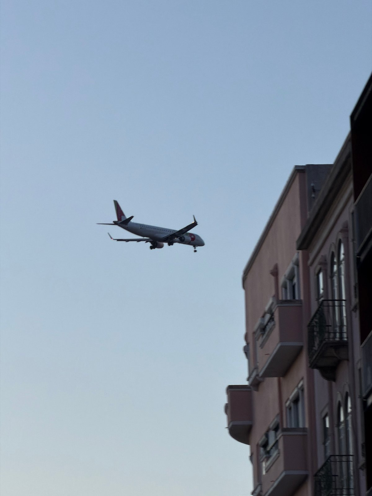 Passenger jet with landing gear spotted near Lisbon building