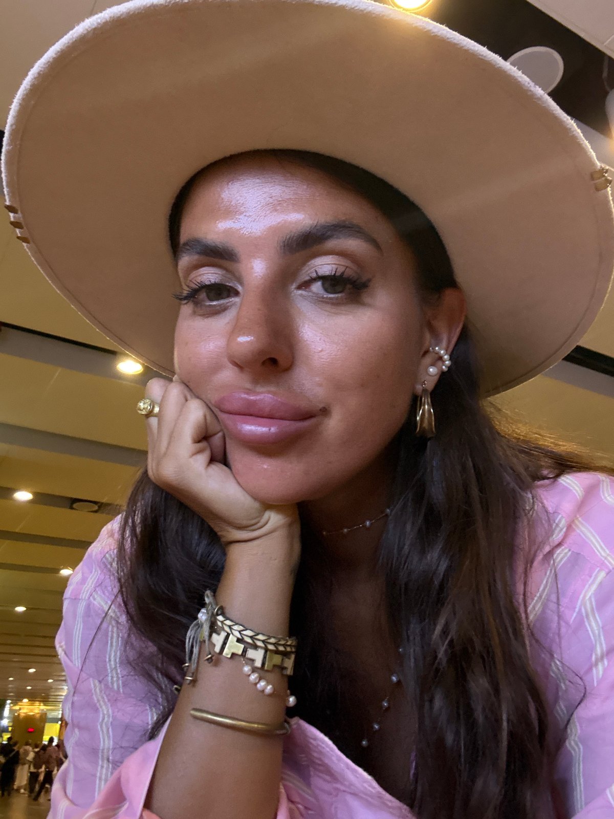 Woman in pink outfit documents airport journey in Kuta
