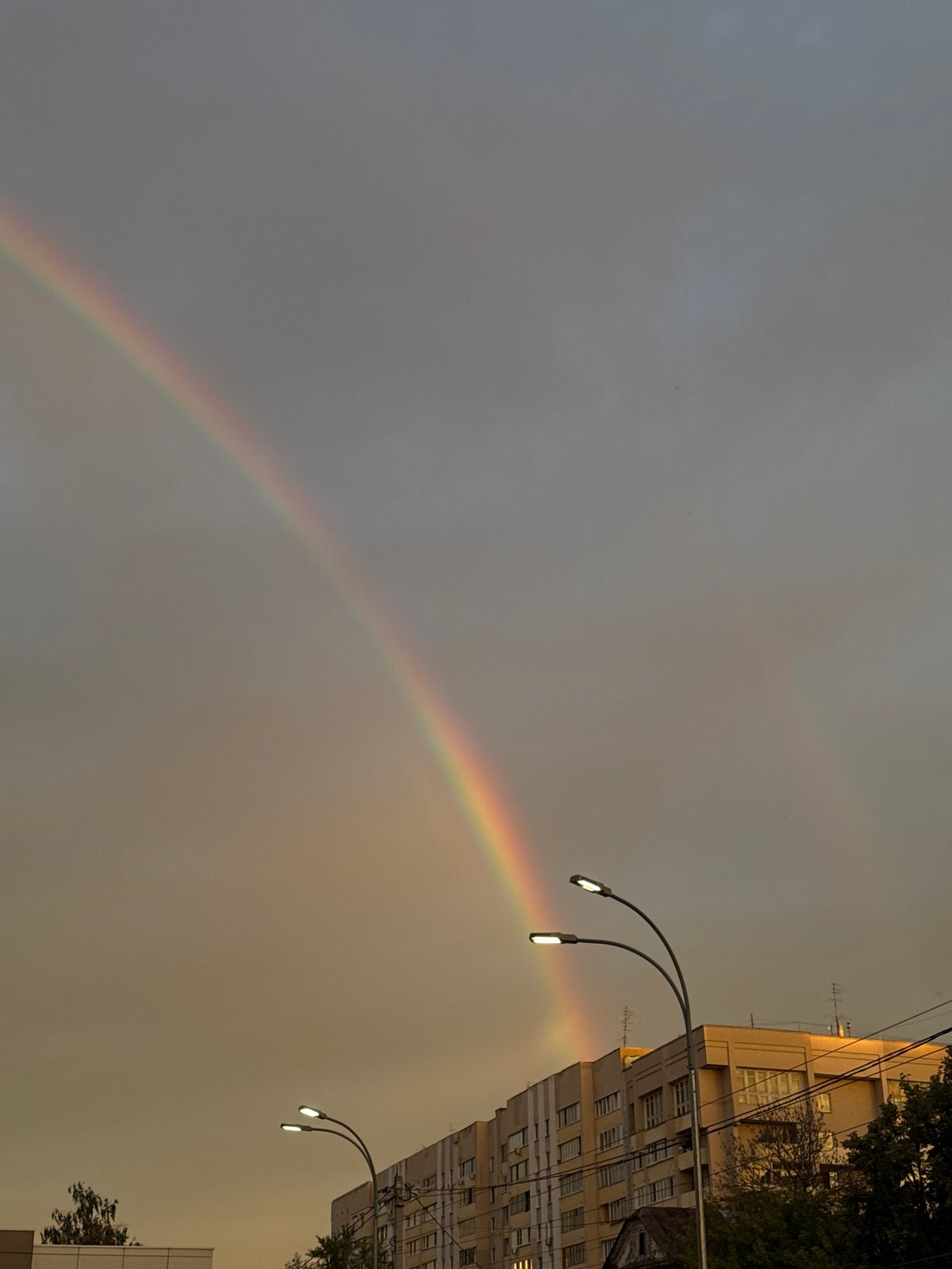 Rainbow over Nizhny Novgorod apartment blocks at golden hour